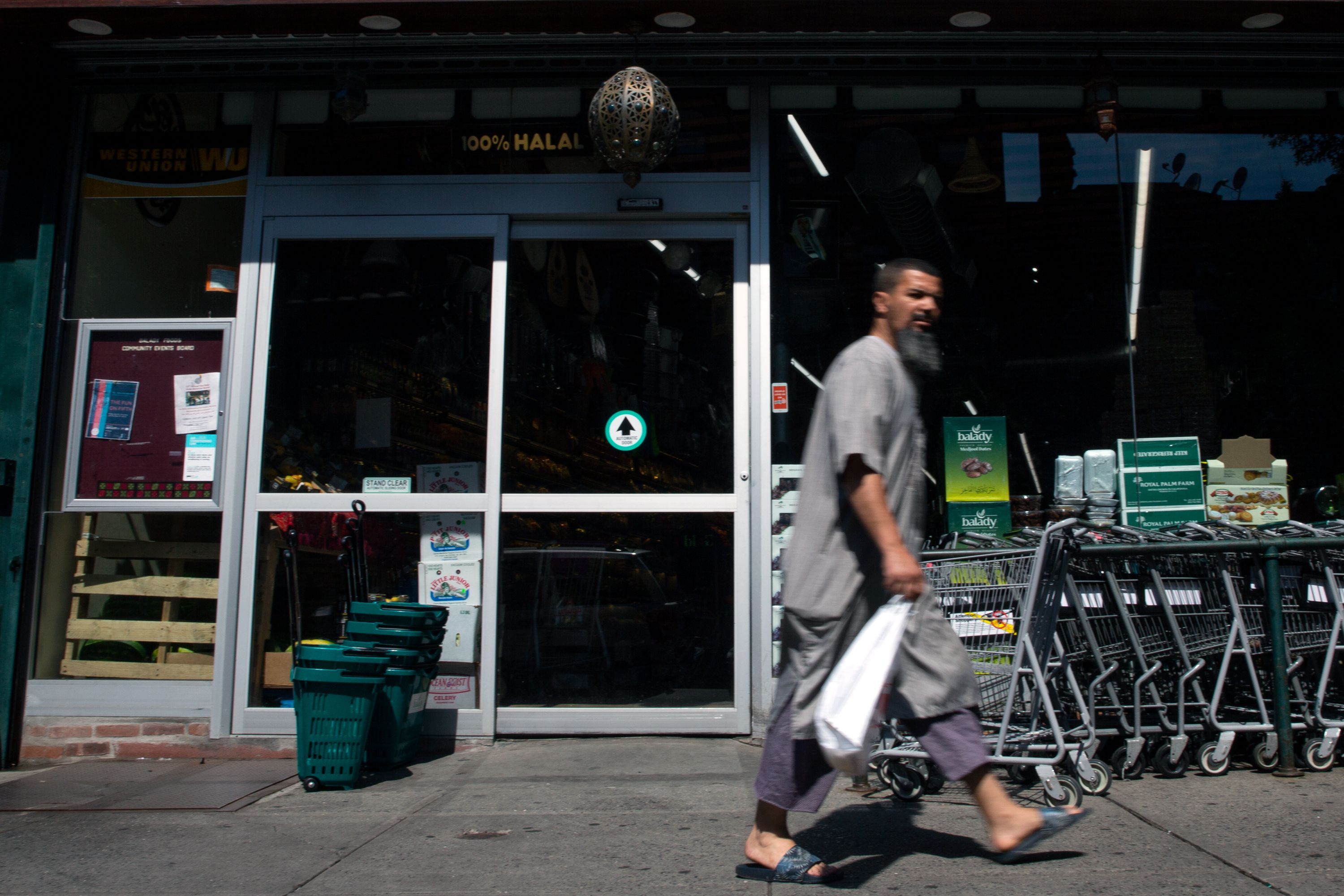 A man walks past a halal grocer on Fifth Avenue and 72nd Street in Bay Ridge, Brooklyn, on July 14, 2019.