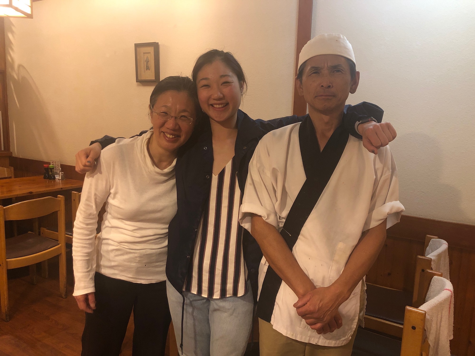A young Olympic skater with her parents at their Japanese restaurant.
