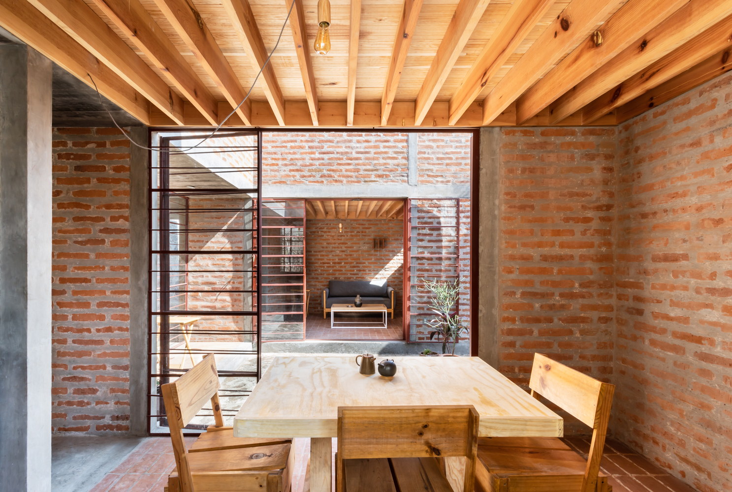 Dining area with wooden table looking out onto courtyard.