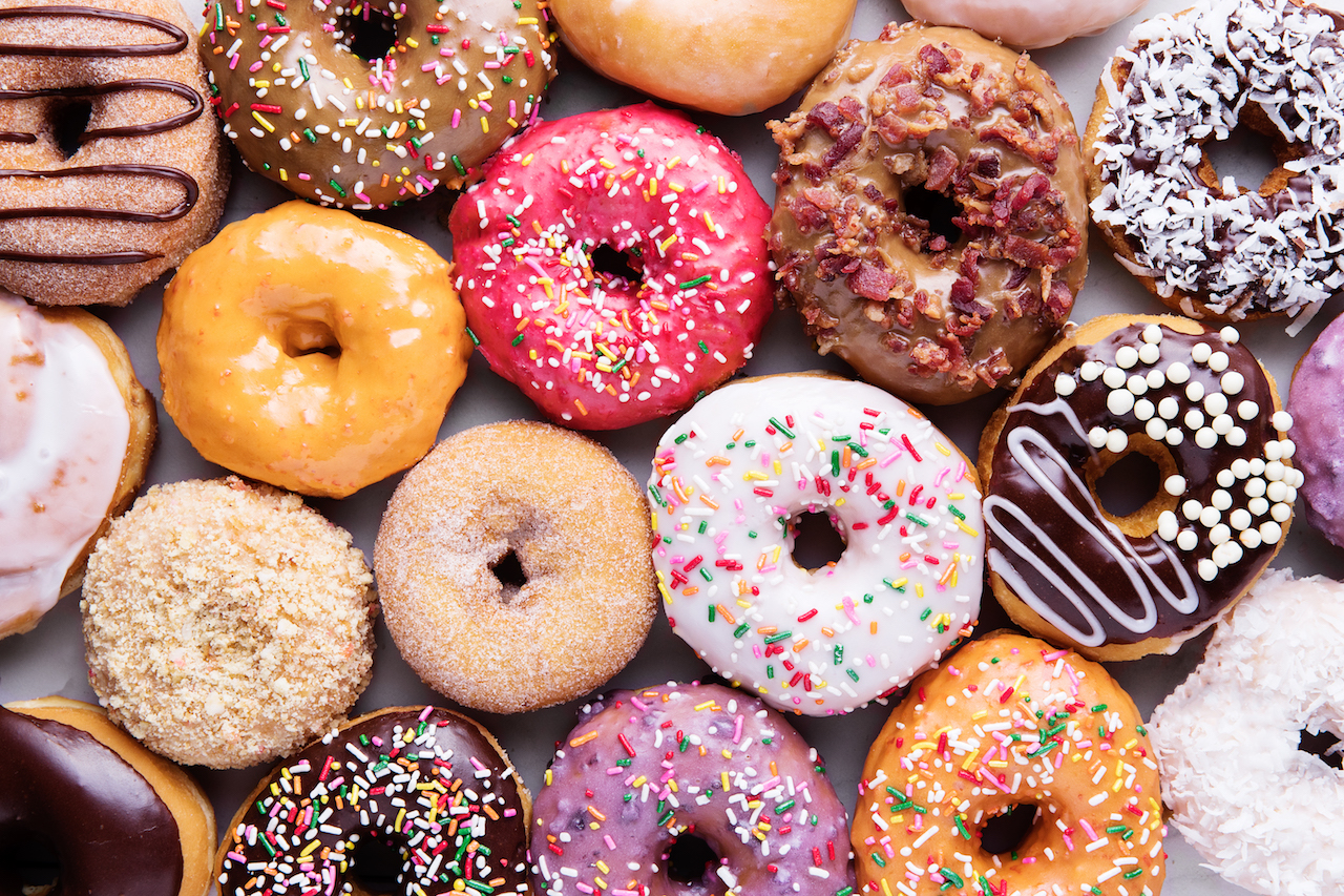 A colorful collection of doughnuts, glazed and sprinkled.