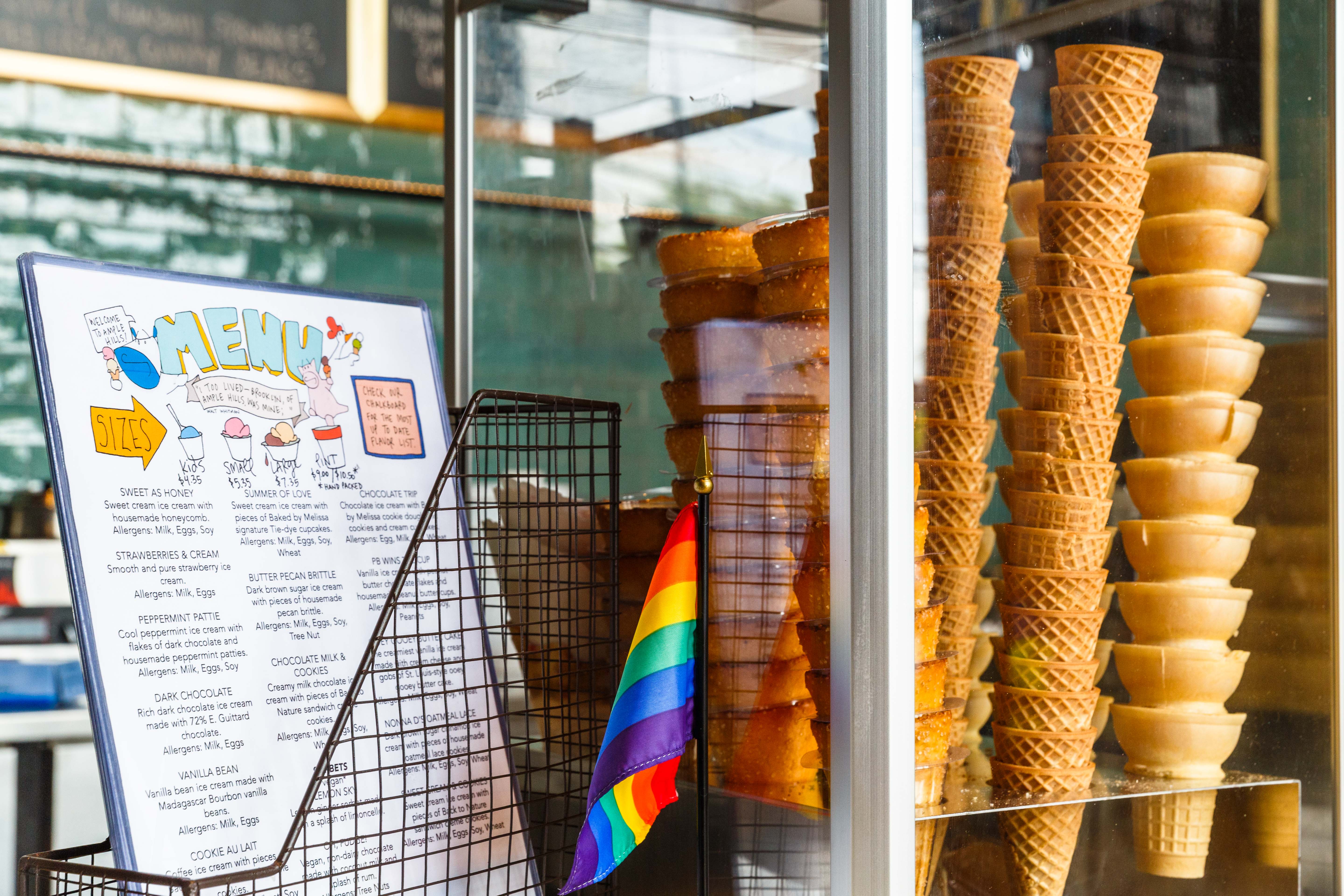 A menu of ice cream flavors next to a stack of ice cream cones inside one of Ample Hills’s shops in Brooklyn