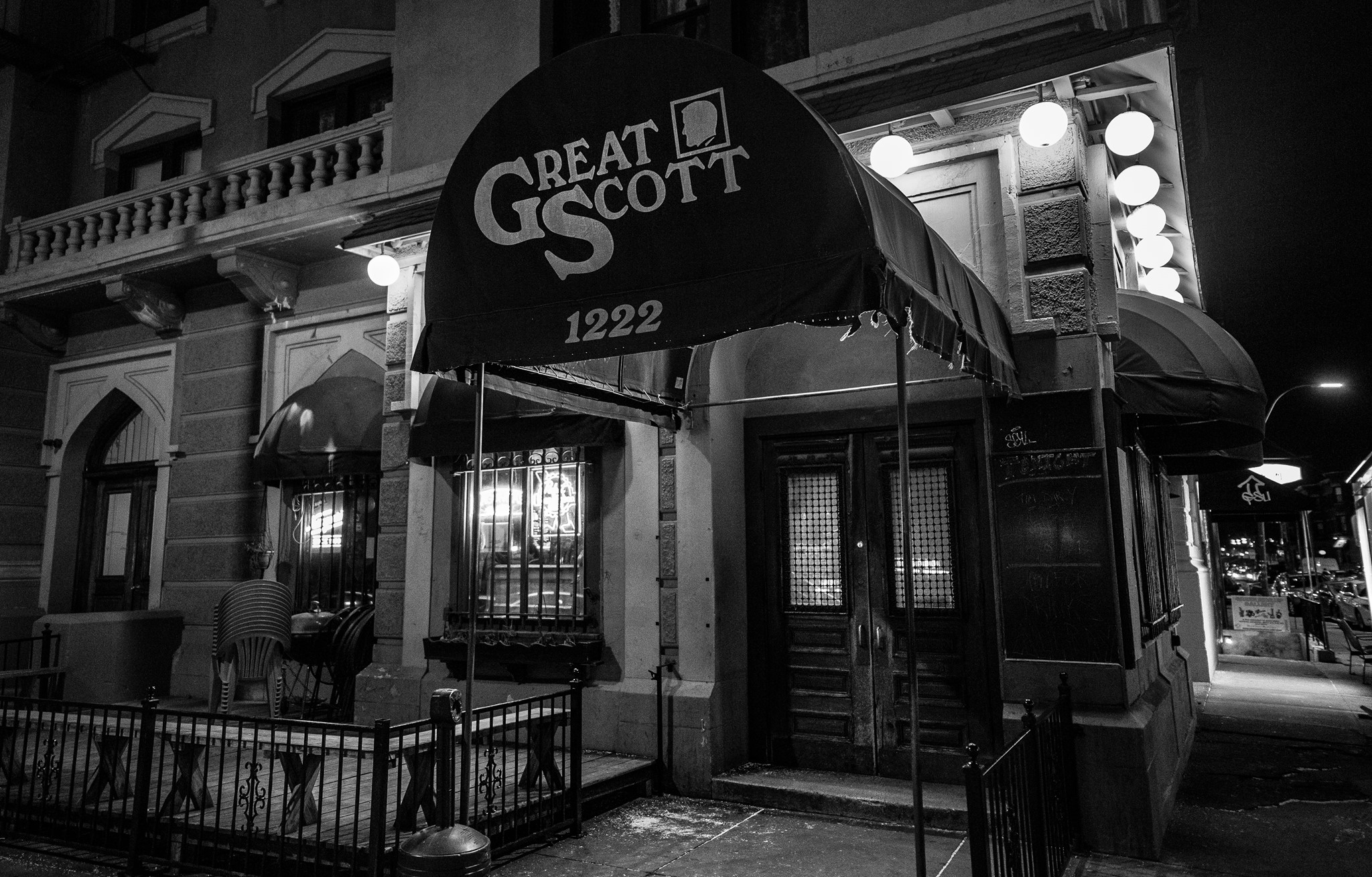 Exterior of a bar, with the name Great Scott written on the awning. The photo is black and white.