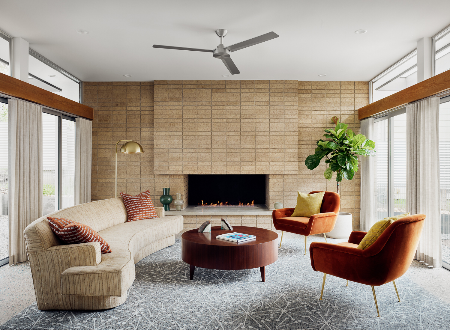 Photo of living room featuring brick fireplace and midcentury furniture.