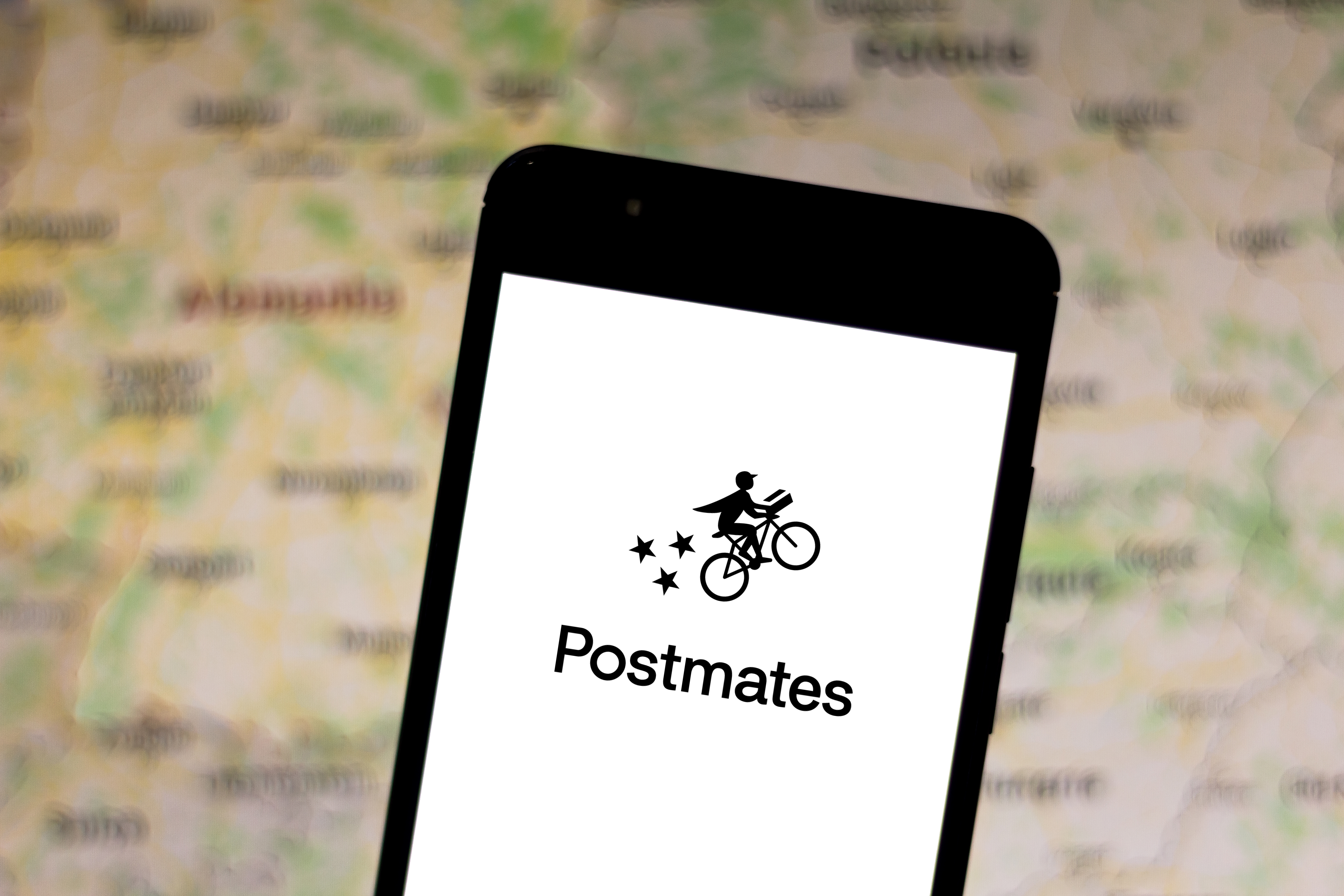 A cell phone displaying the Postmates logo