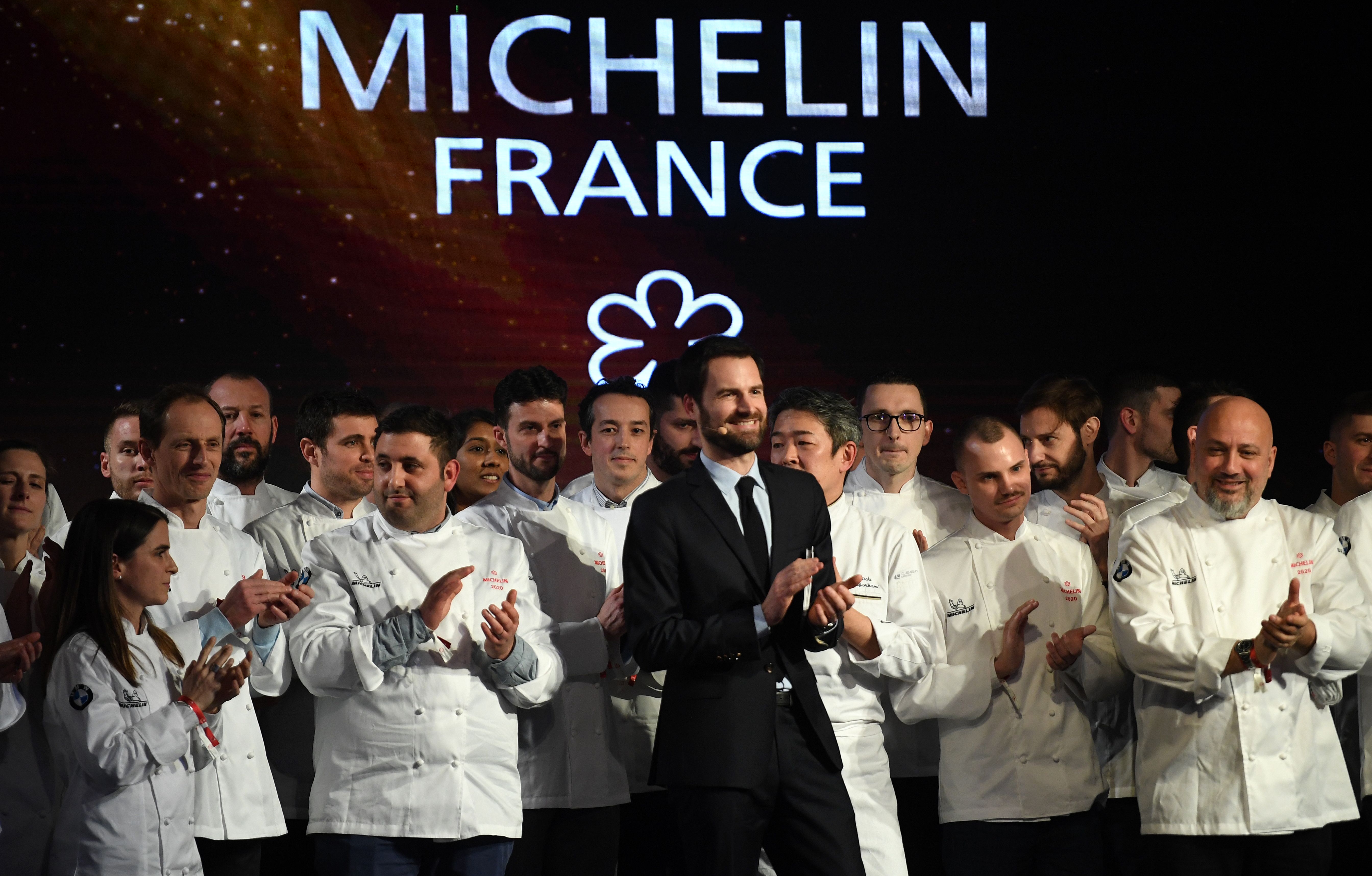 People on stage in front of a Michelin sign