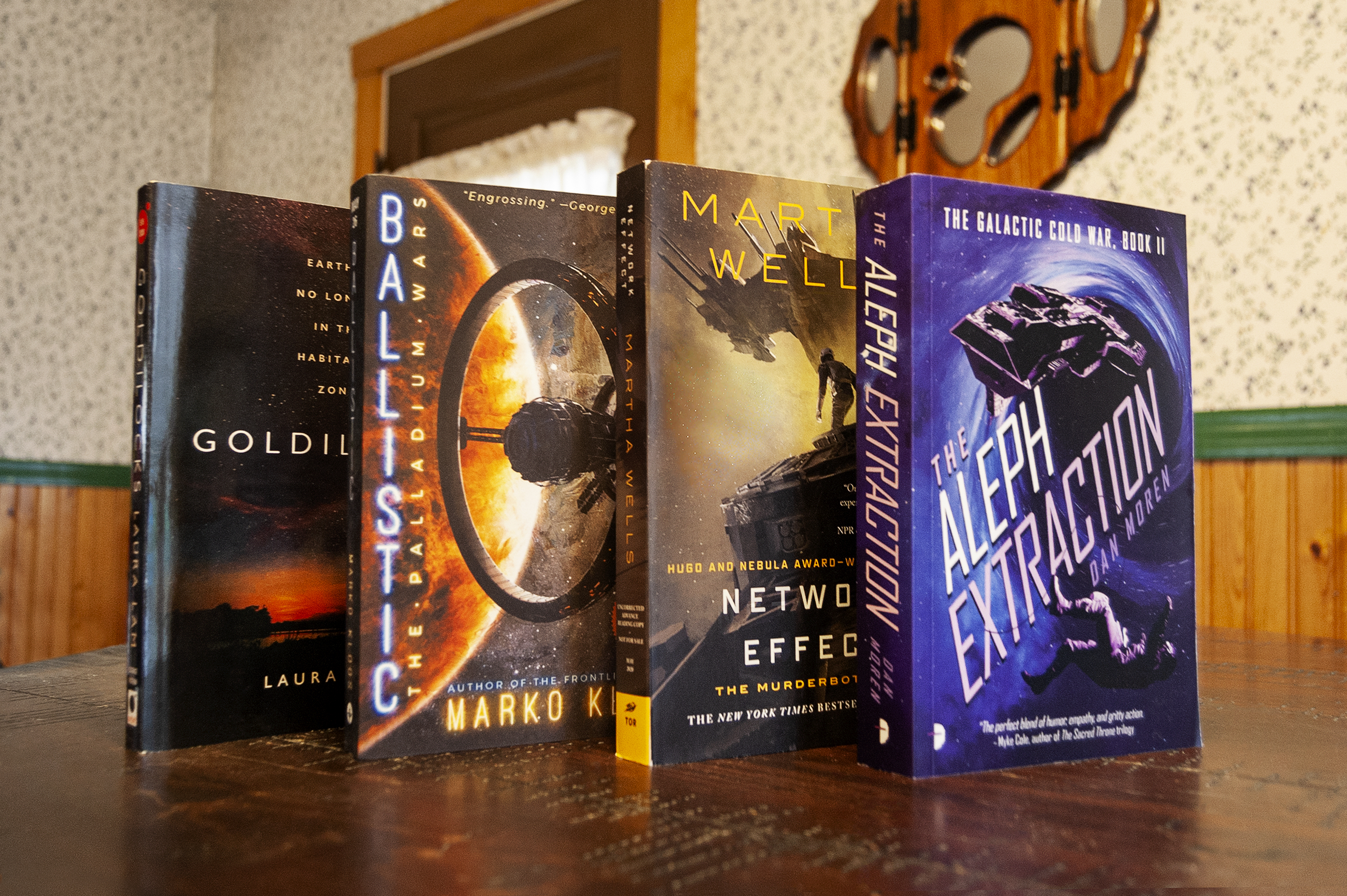 Four science fiction books upright on a book shop counter