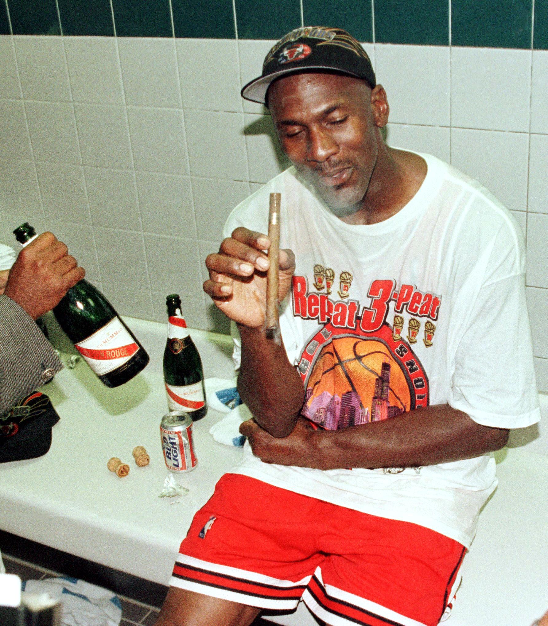 Michael Jordan enjoys a cigar after the Bulls beat the Jazz in Game 6 of the 1998 NBA Finals. It was his sixth title.