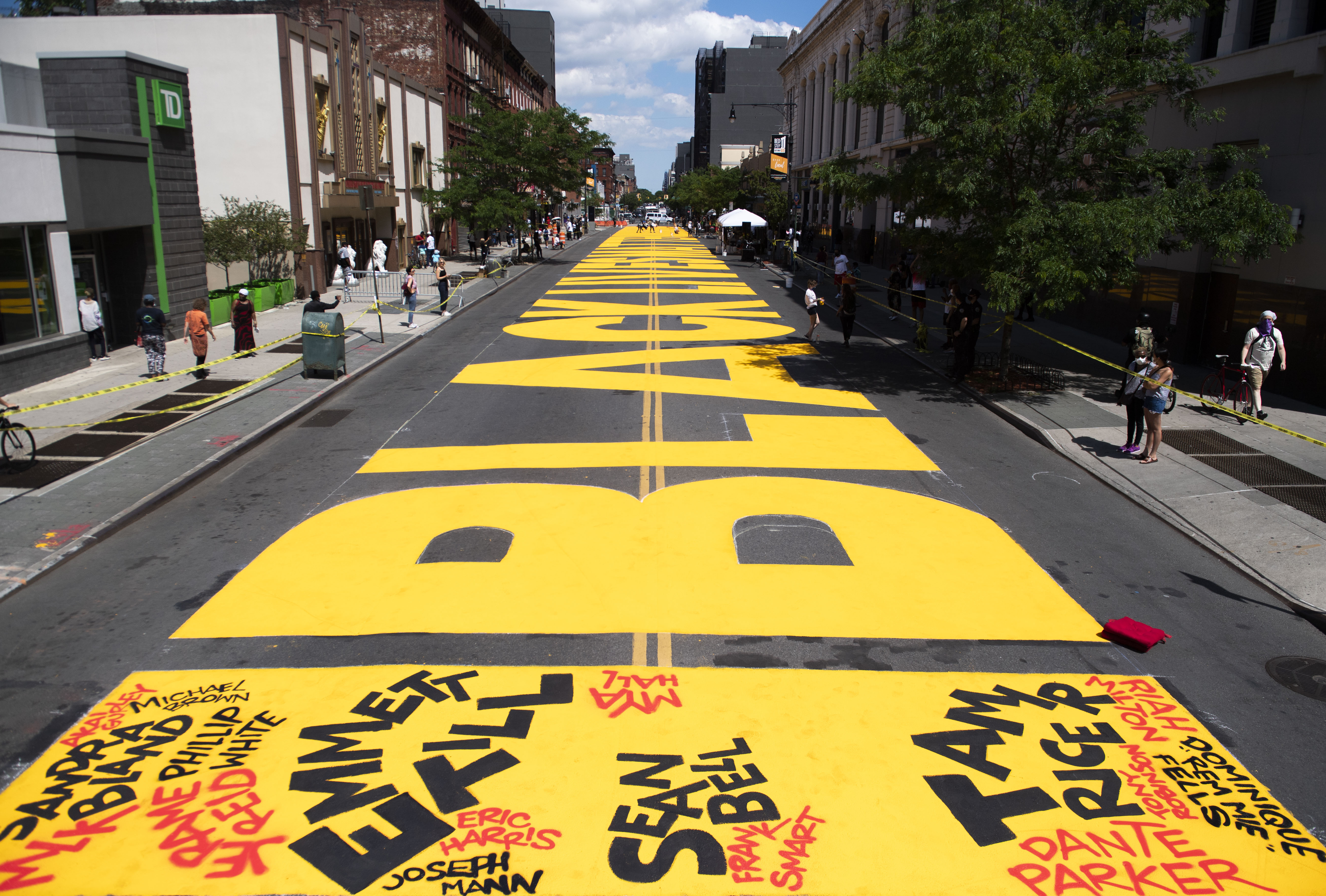 Black Lives Matter spelled out in big, bright yellow lettering on a Brooklyn street. 