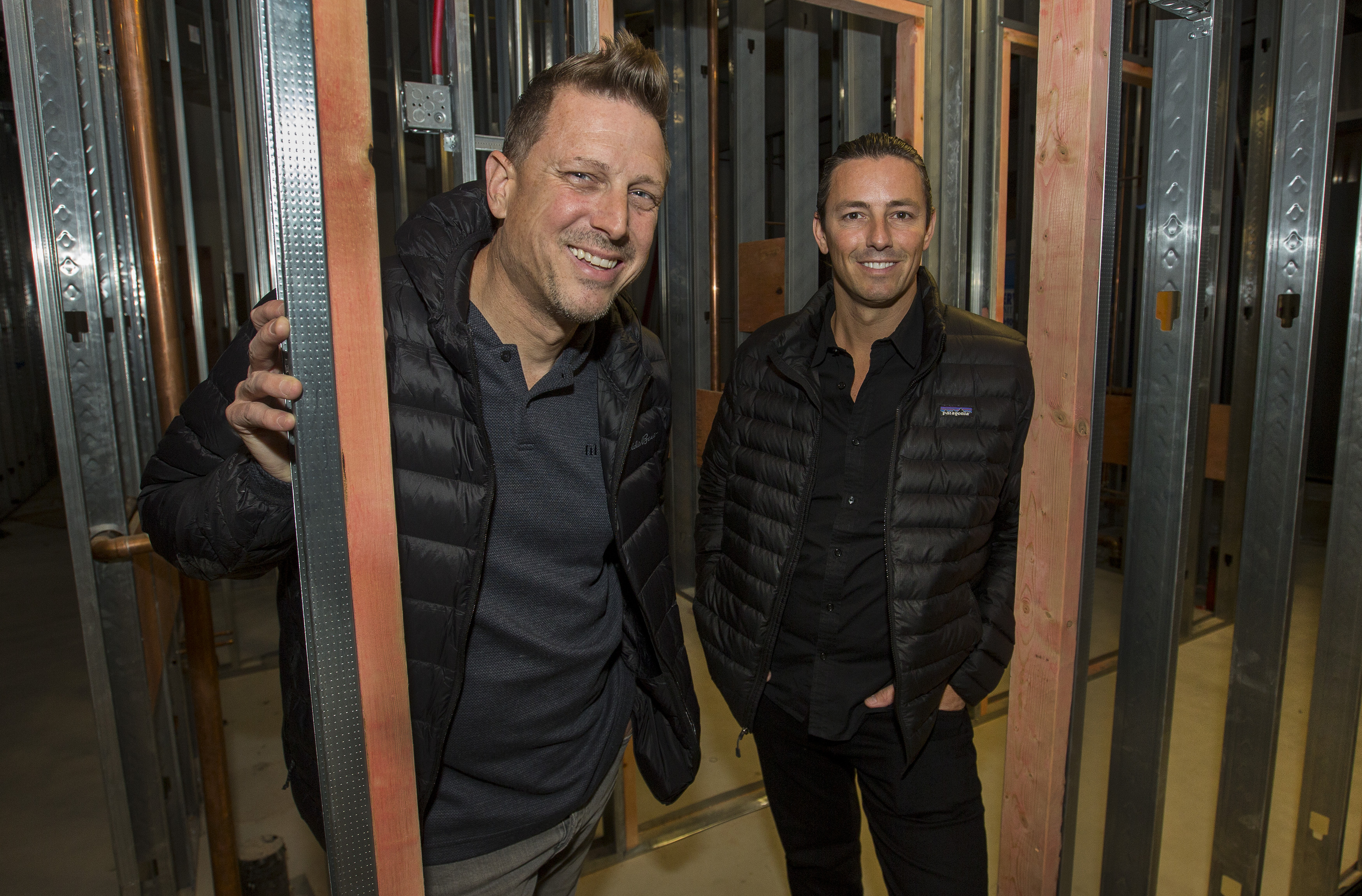 The chef and general manager pose around steel beams in a different part of their under-construction restaurant.