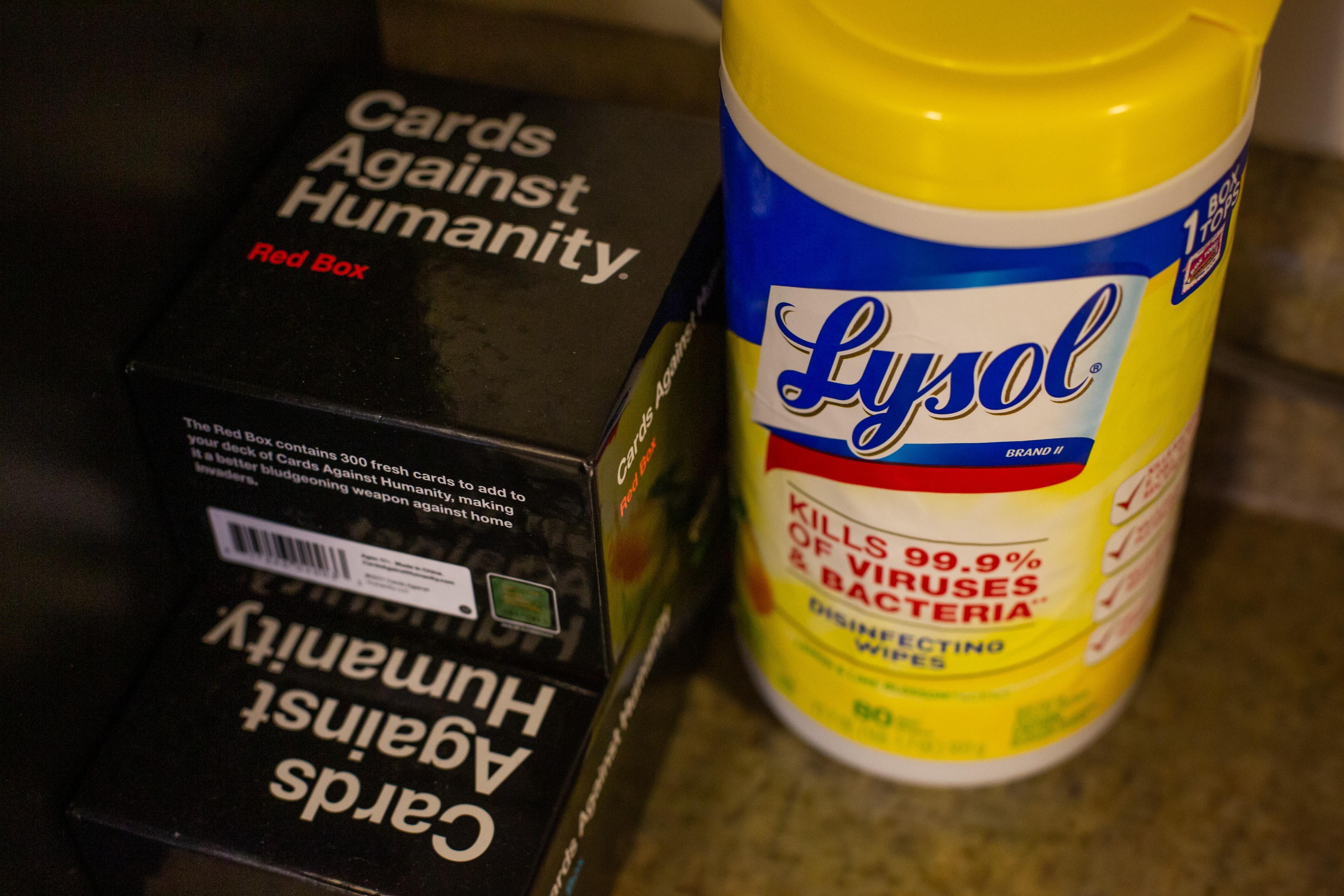 Lysol wipes and a Cards Against Humanity game sit on a counter together.