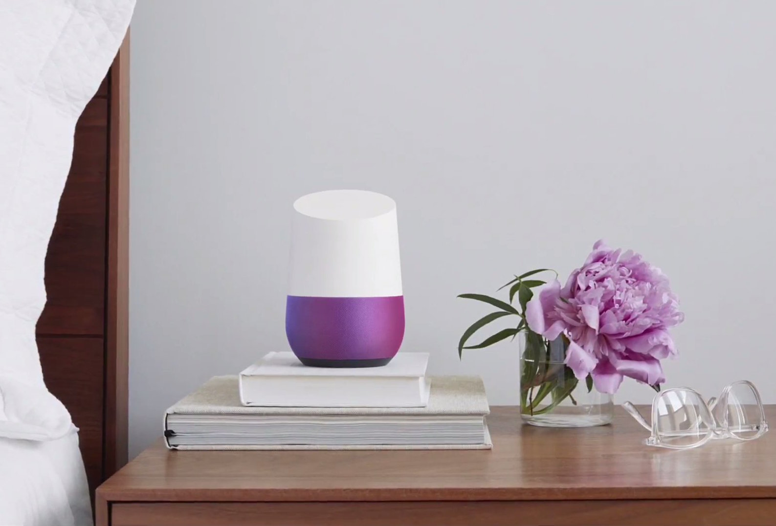 A Google Home device on a bedside table.