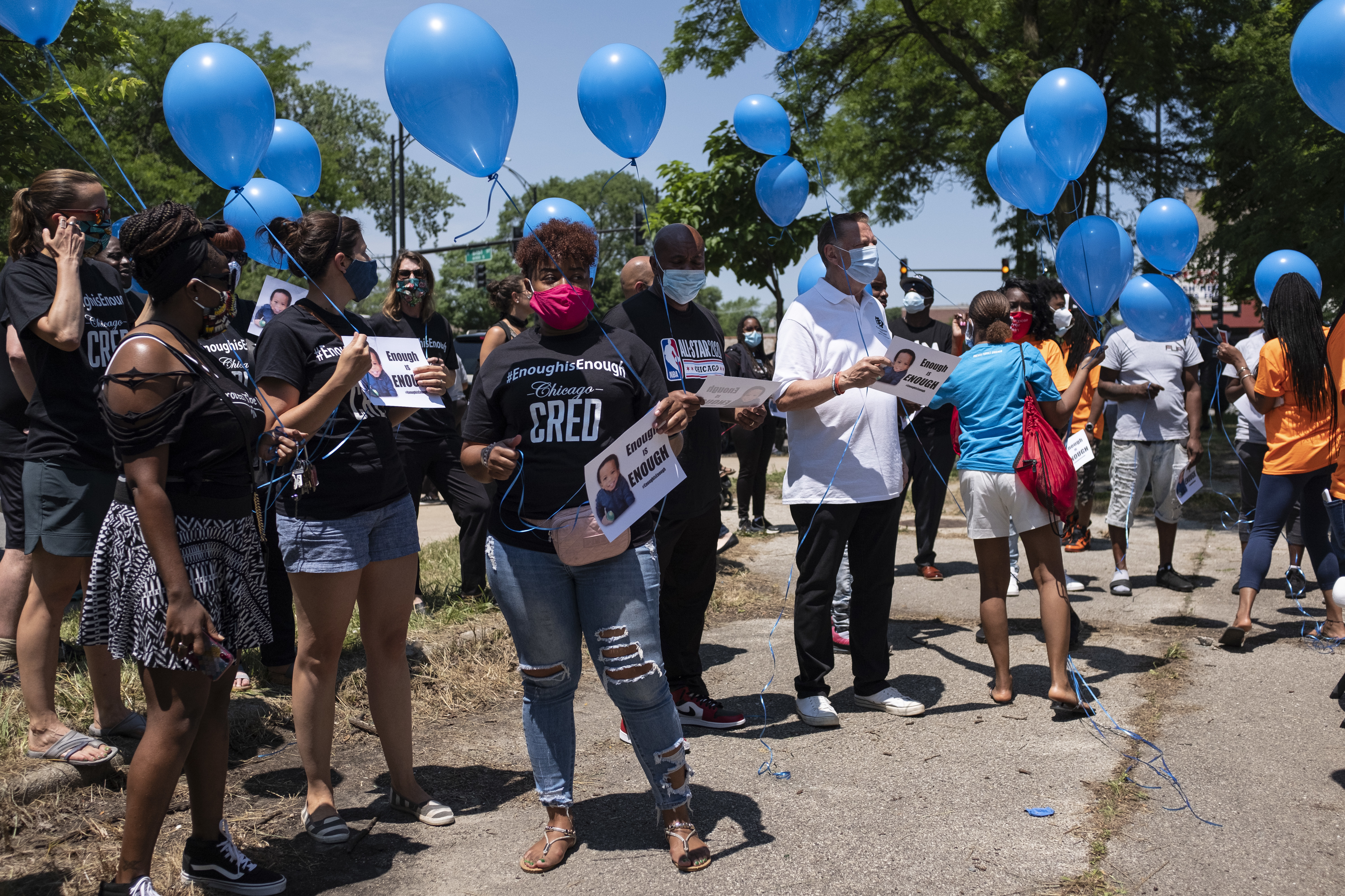 Friends and family hold balloons and sign during a vigil for Sincere A. Gaston on Wednesday.