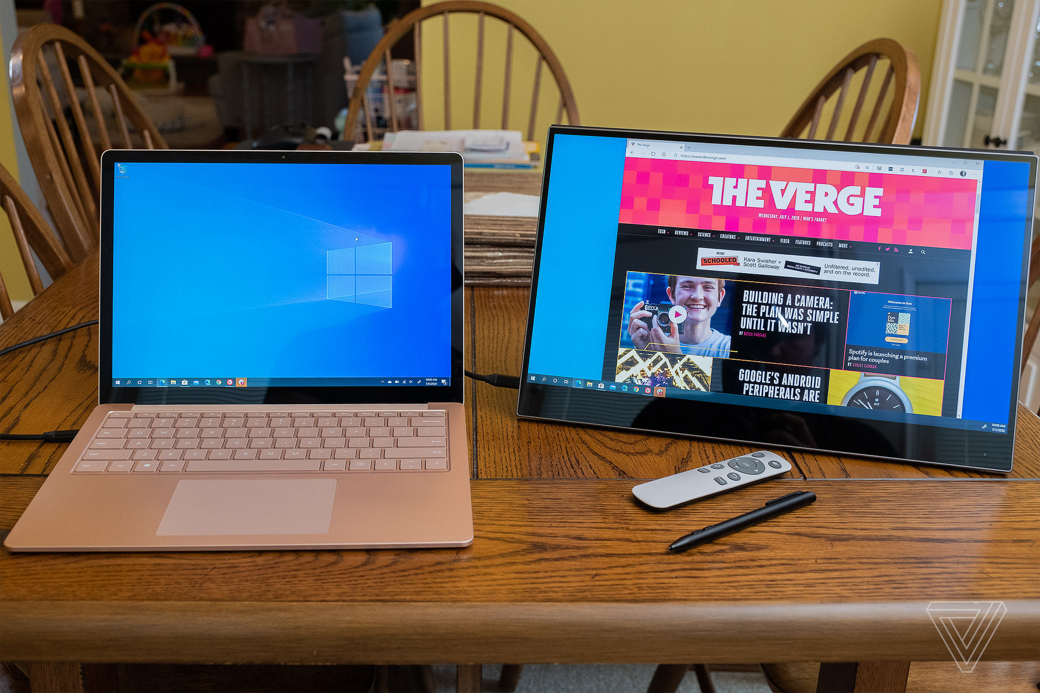 The Ananta touchscreen portable display plugged into a Surface Laptop 3 on a wooden table.