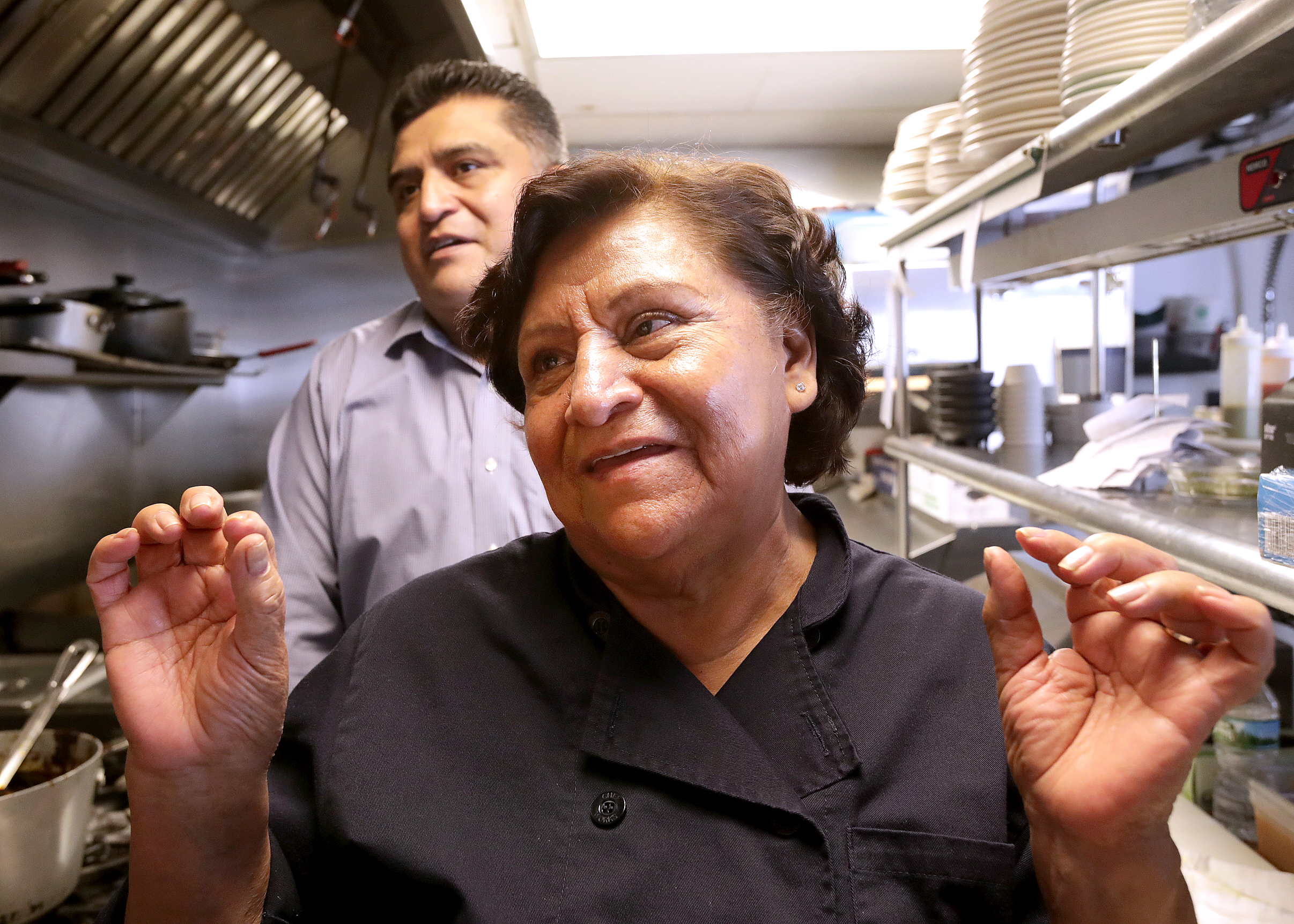 Closeup shot of a woman and her adult son in the kitchen of a restaurant