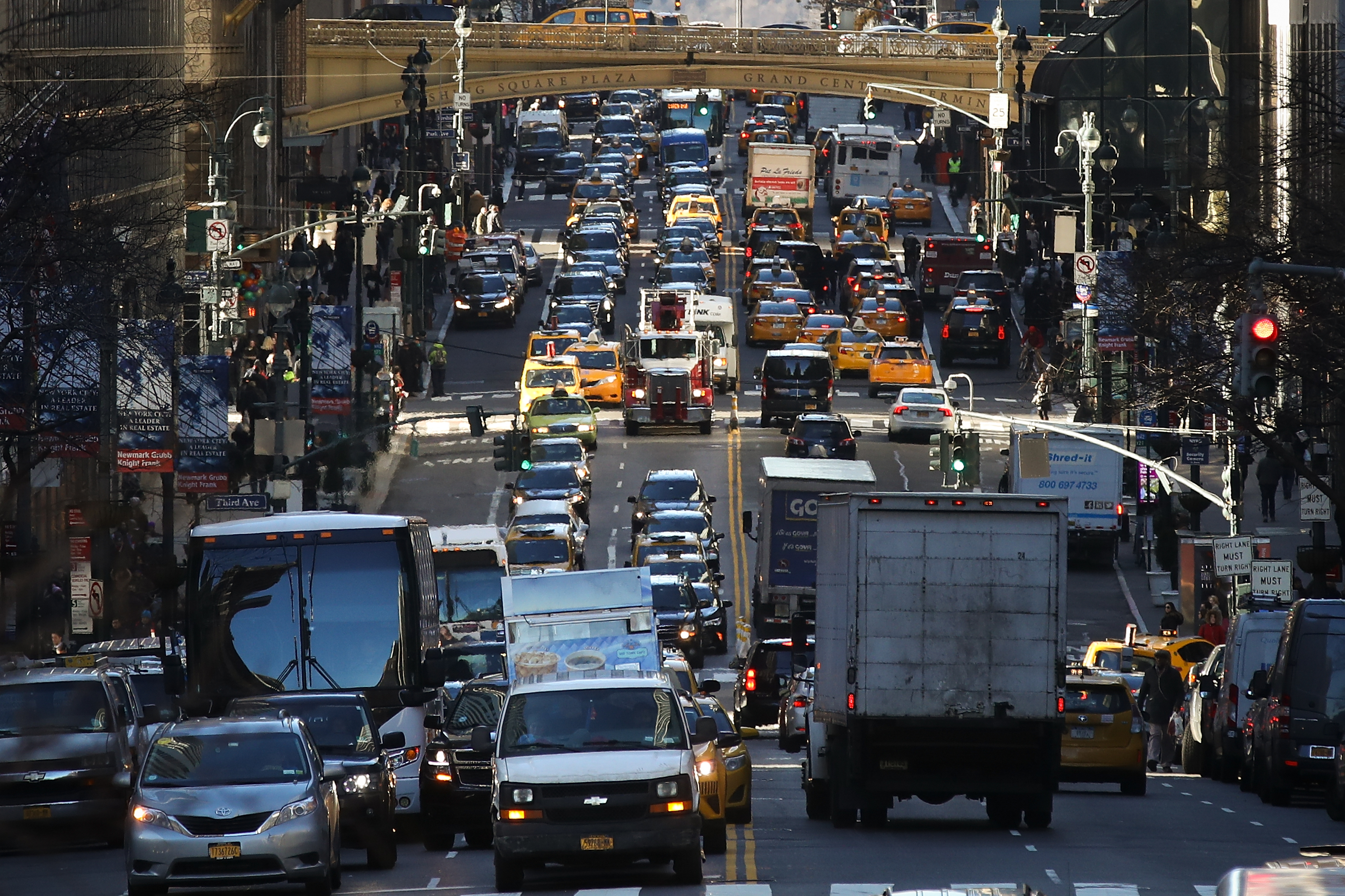 A congested road in Manhattan packed with cars, trucks, and buses bumper-to-bumper.