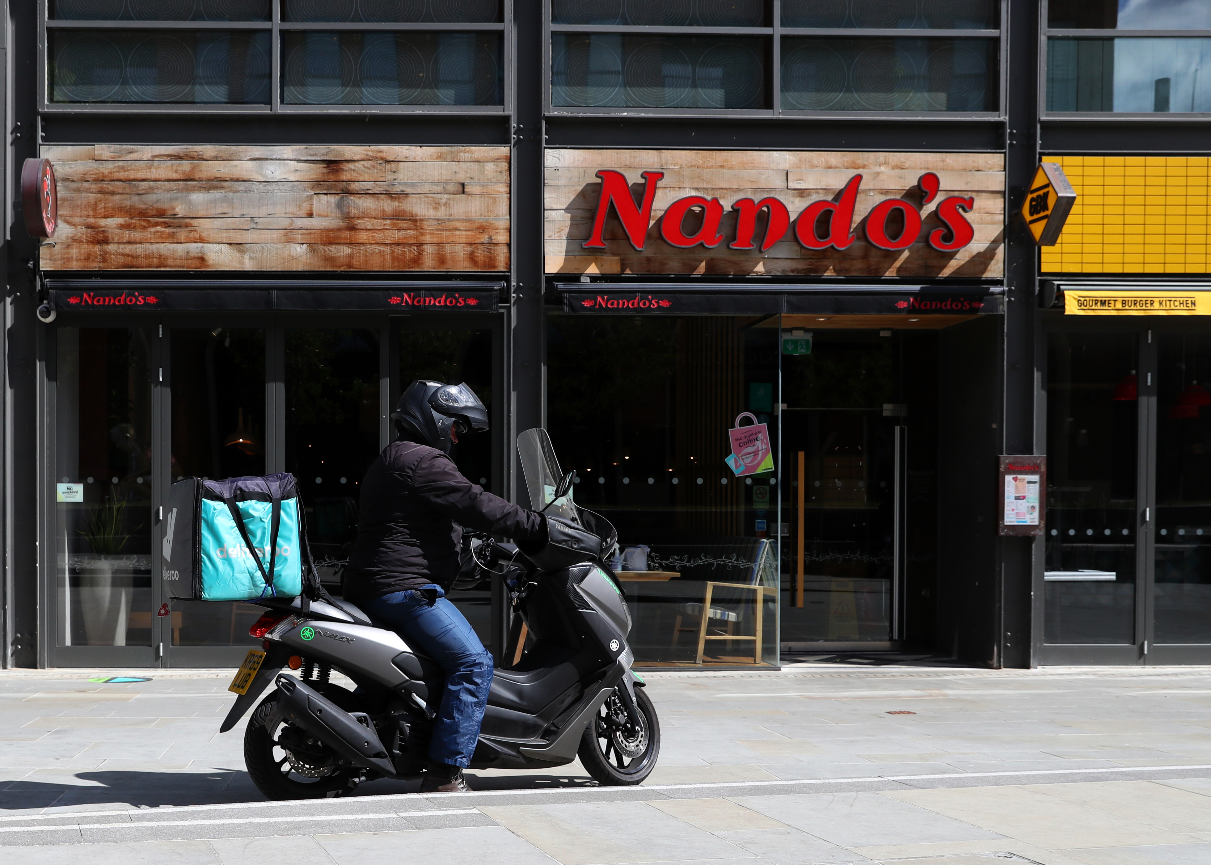 A Nandos restaurant in England with a delivery rider outside