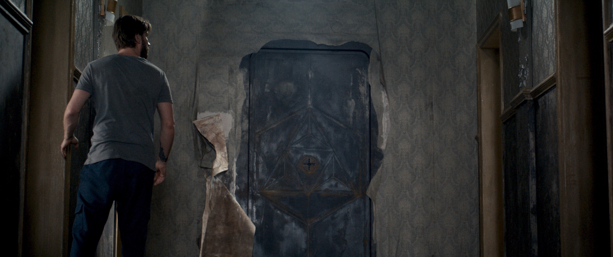 Kevin Janssens looks at a mysterious, ominous metal door previously covered by wallpaper in The Room.