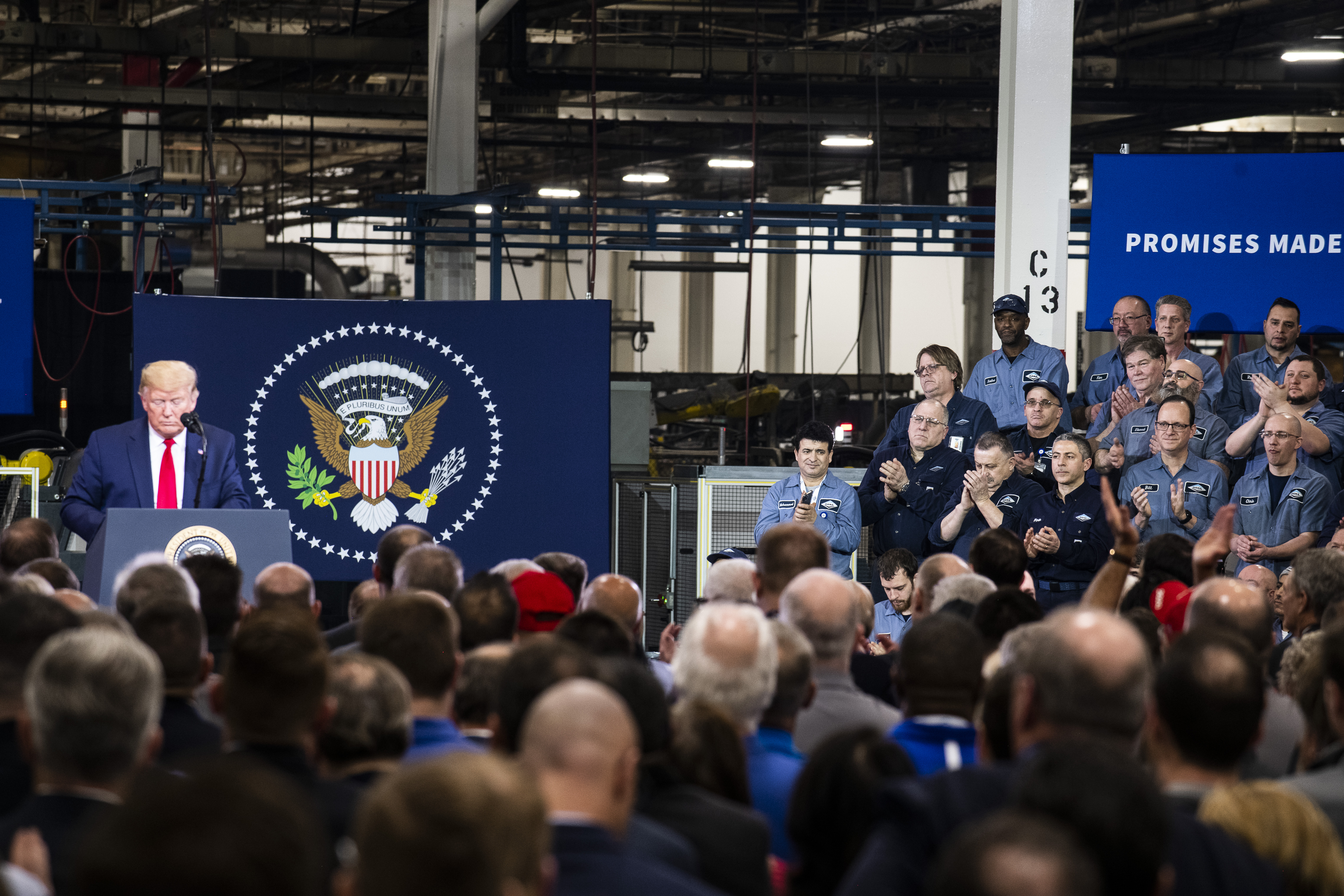 Employees look on as President Donald Trump speaks at Dana Incorporated, an auto-manufacturing supplier, on January 30, 2020 in Warren, Michigan.