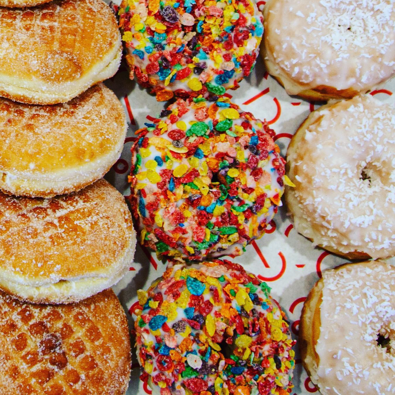 Three rows of jelly-filled, Fruity Pebbles, and frosted doughnuts from Hero Doughnuts