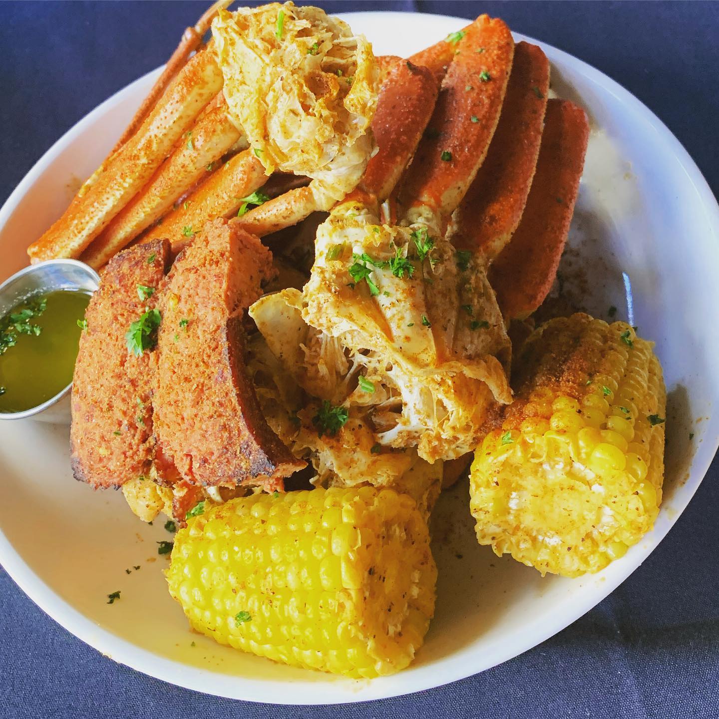 A plate of crab legs, butter, and corn on the cob from Sweet Auburn Seafood