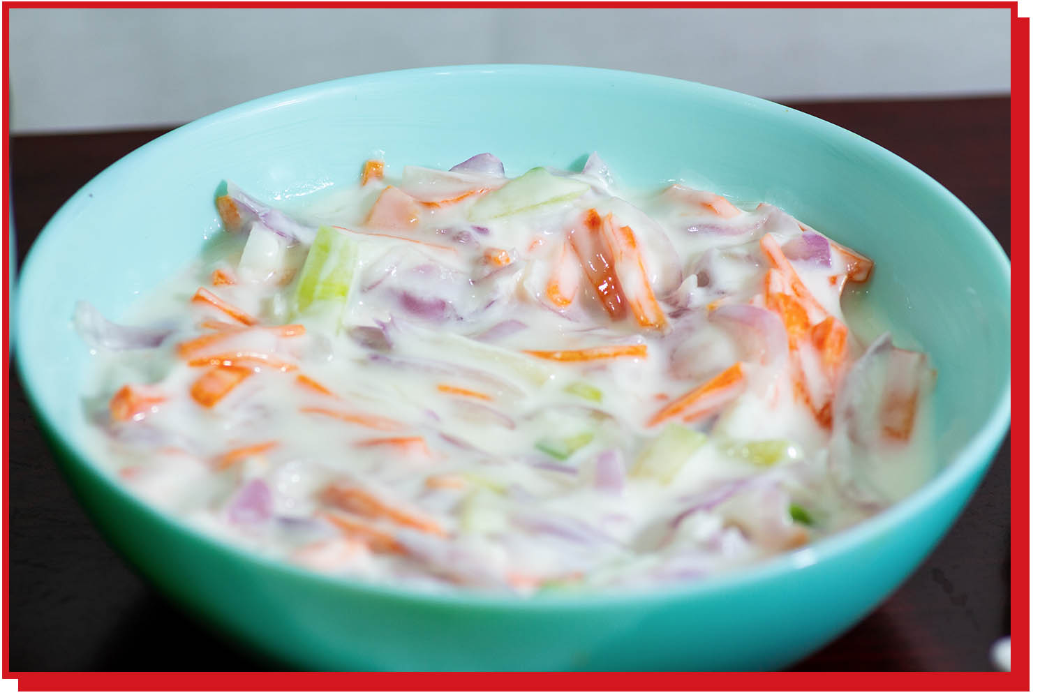 A bowl of shredded carrots, celery, and onions mixed in yogurt.