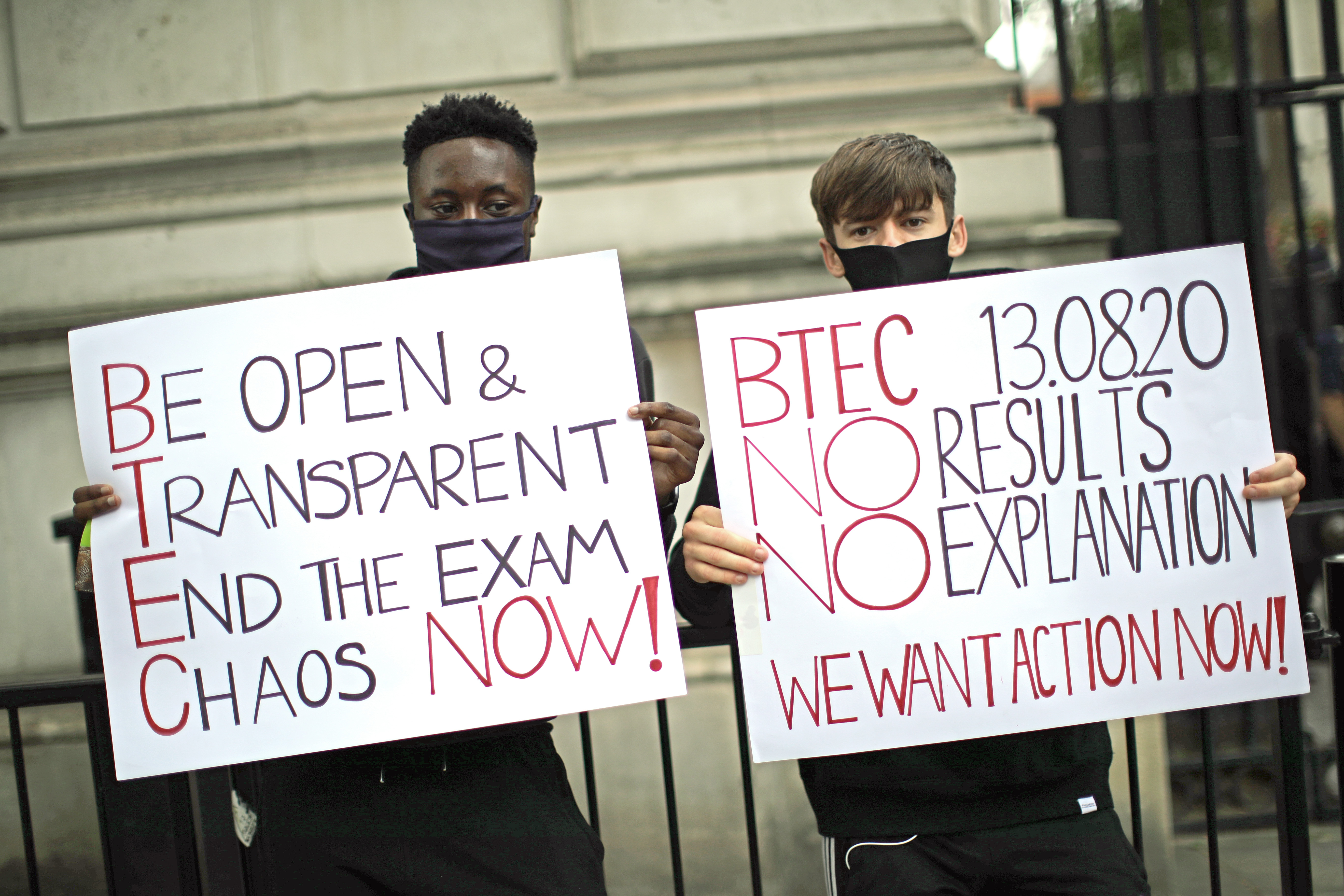 Protesters hold signs that read, “Be open &amp; transparent, end the exam chaos now!” and “BTFC 13.08.20 no results, no explanation. We want action now!”