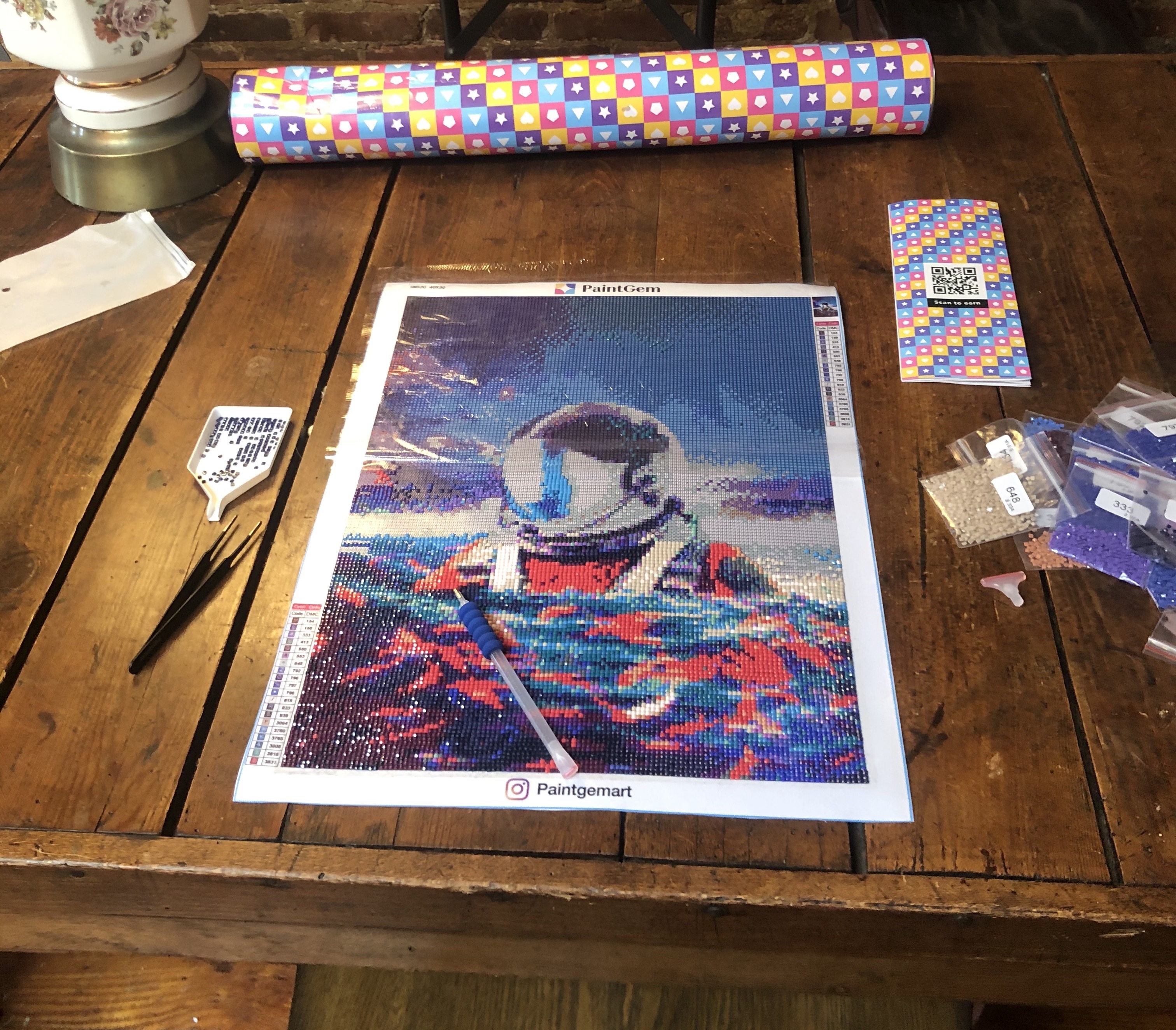 A gem painting canvas featuring an astronaut wading in the ocean