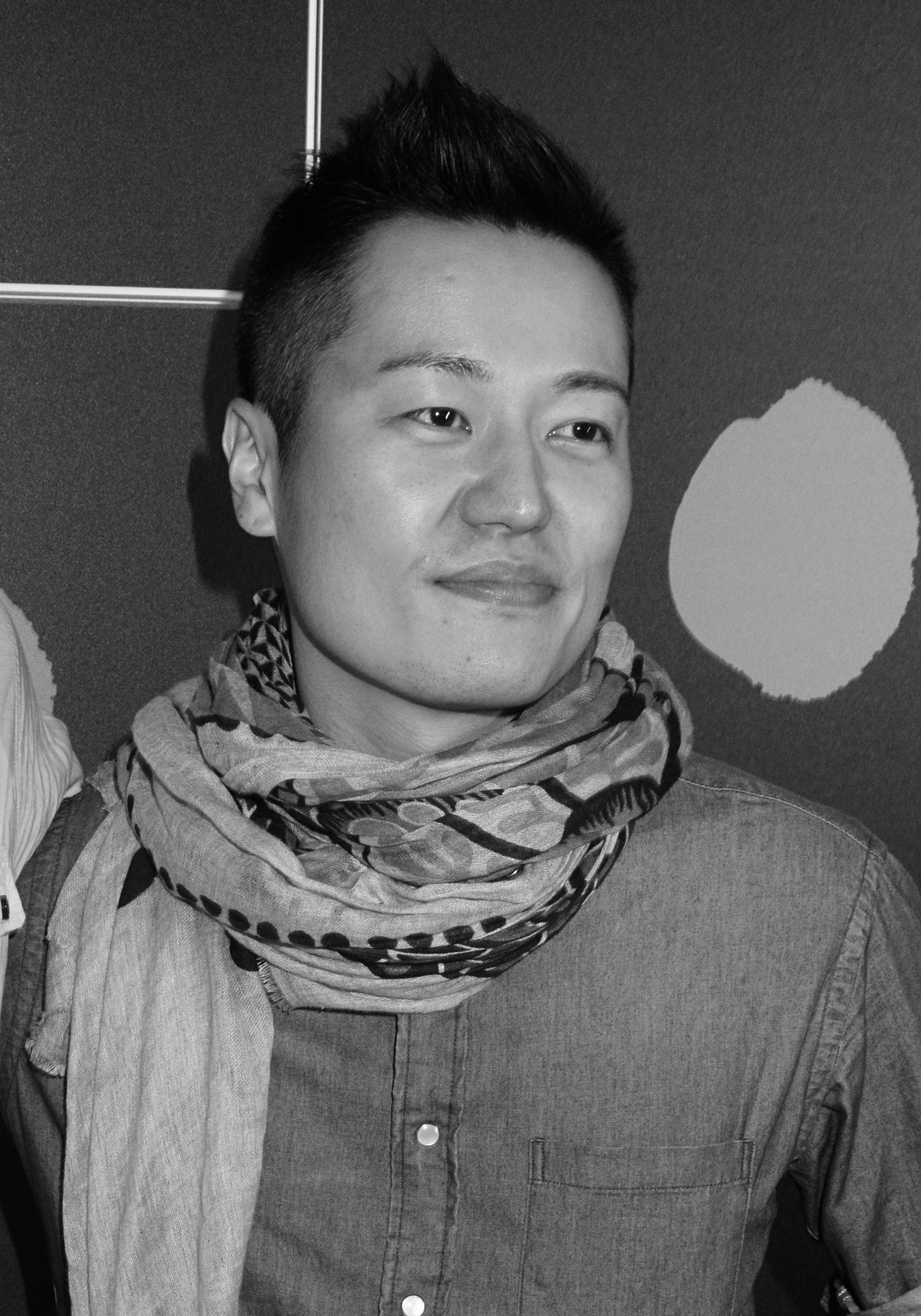 Close-up, black and white photo of a man wearing a scarf.