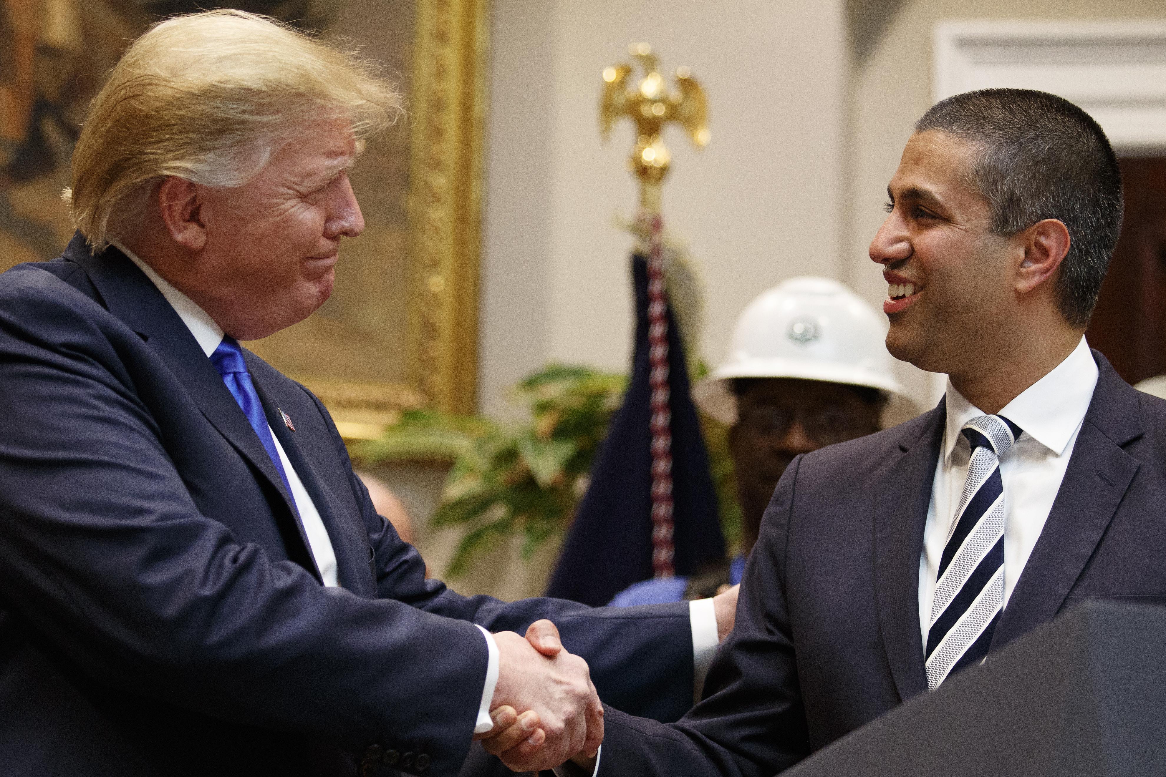 President Donald Trump and FCC Chair Ajot Pai shake hands.