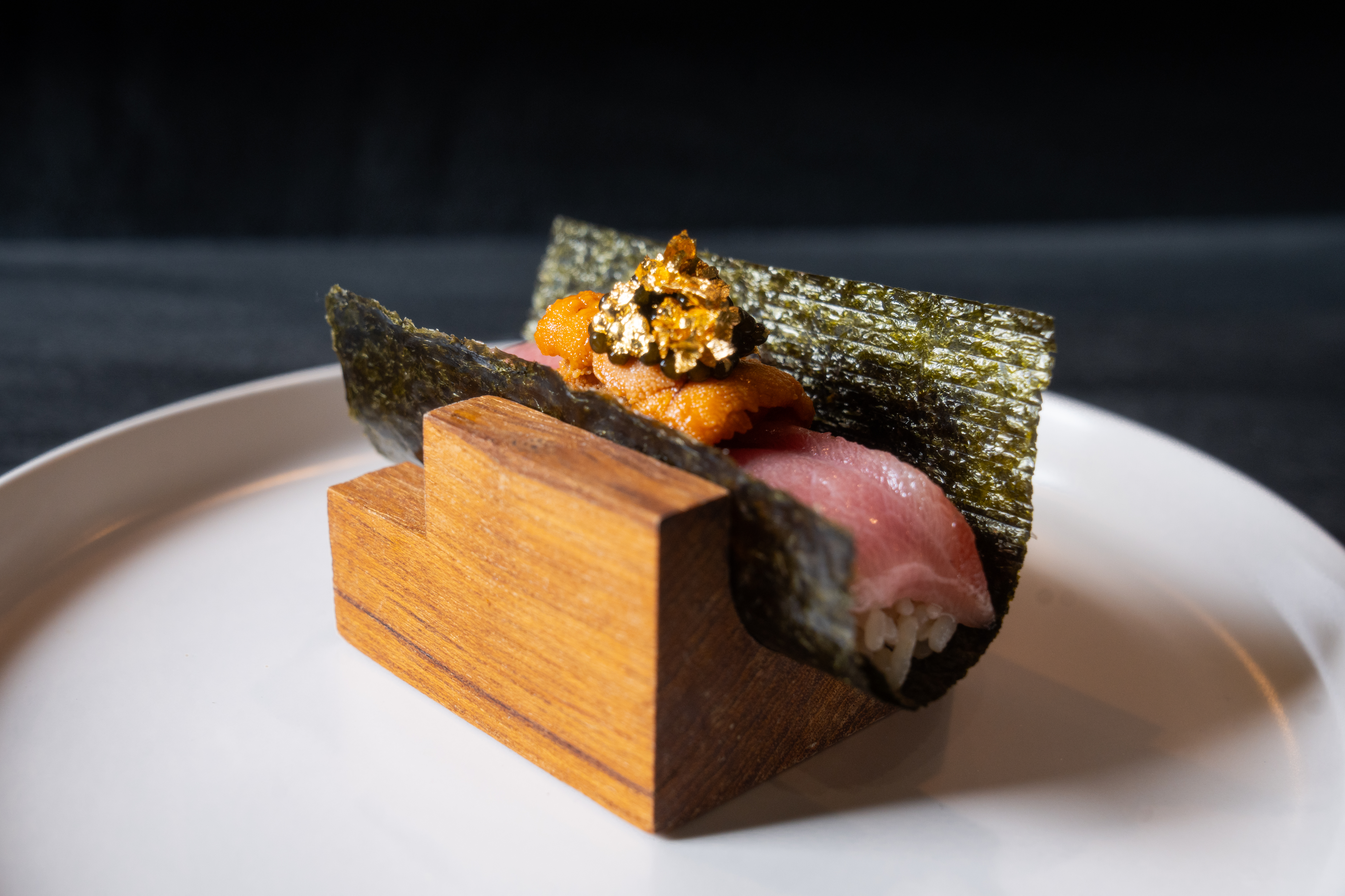 A Norigami handroll with toro and wagyu, topped with uni and a gold flakes.