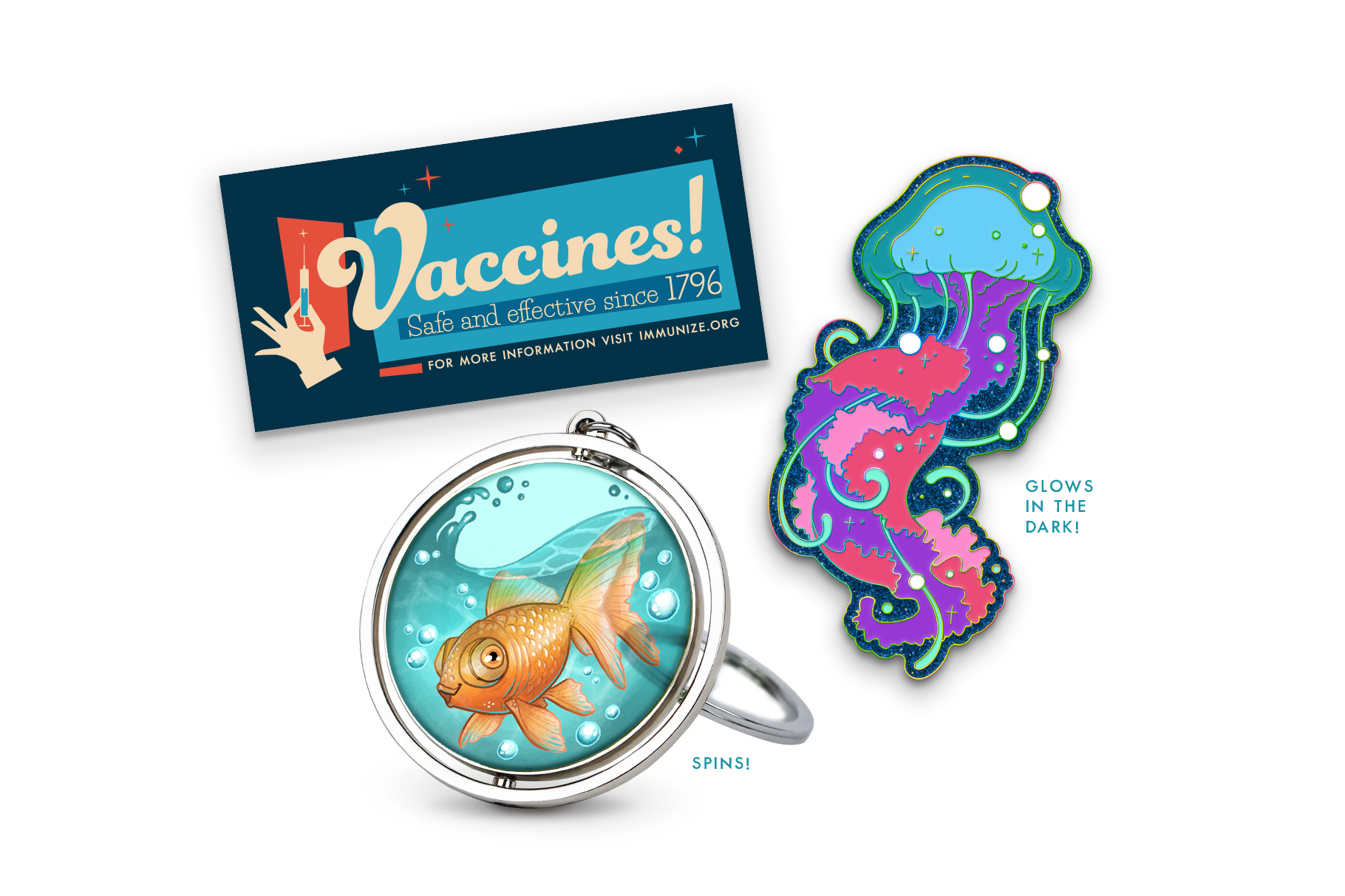 Image of the three November McElroy merch items: a blue bumper sticker that says “Vaccines! Safe and effective since 1796”, a spinning translucent acrylic keychain with an illustration of Stephen the Fish, and an enamel voidfish pin that glows in the dark.