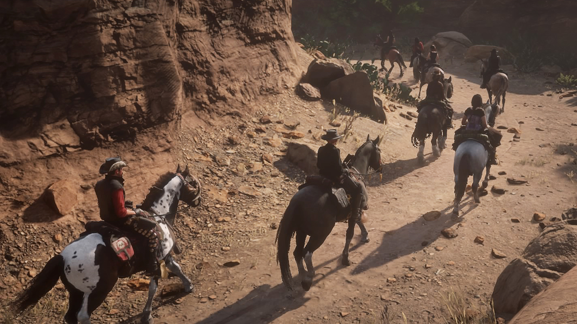 A group of riders and horses in a canon from the Red Dead Redemption 2 video game
