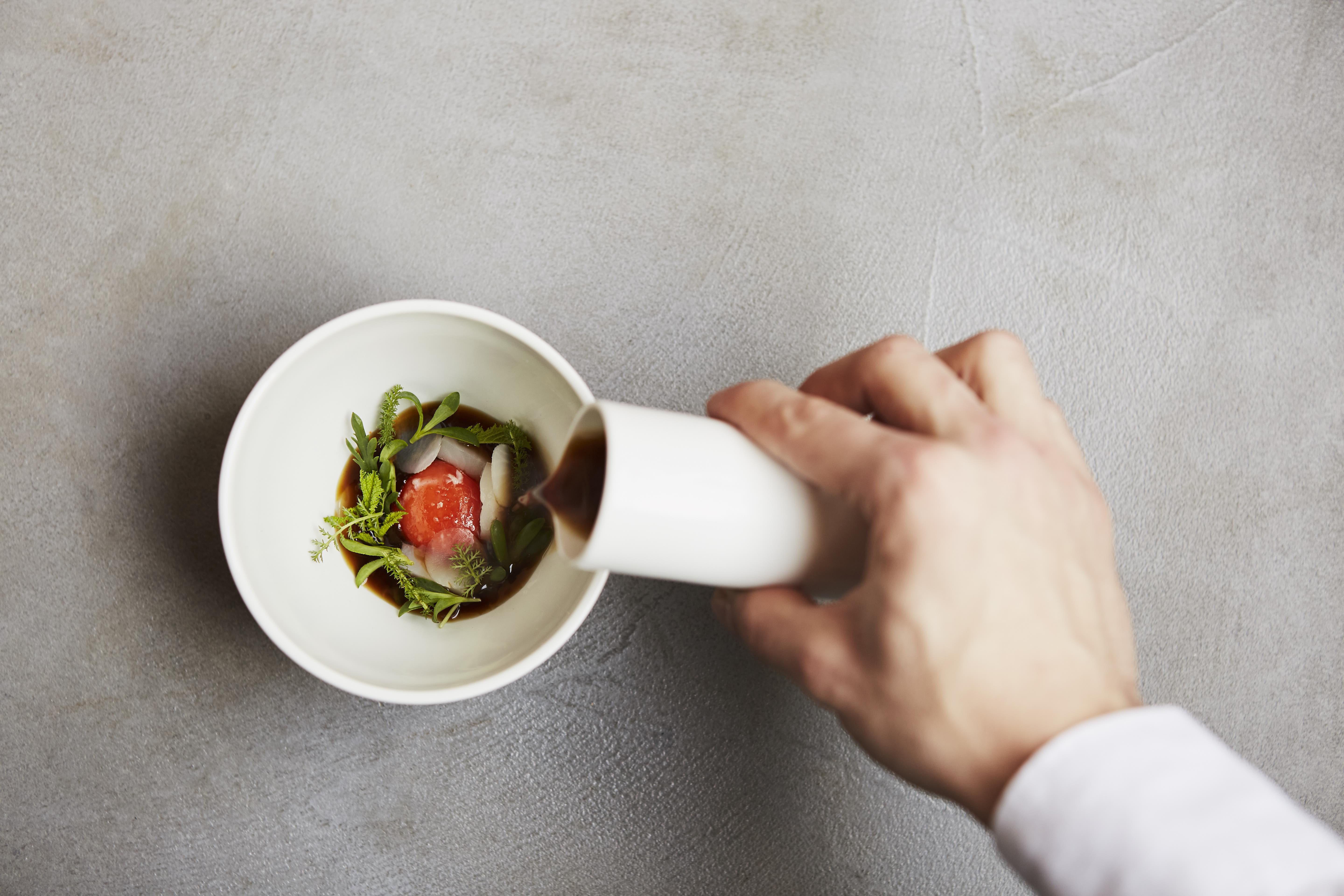 A sauce being poured over a bowl at Roganic in Marylebone