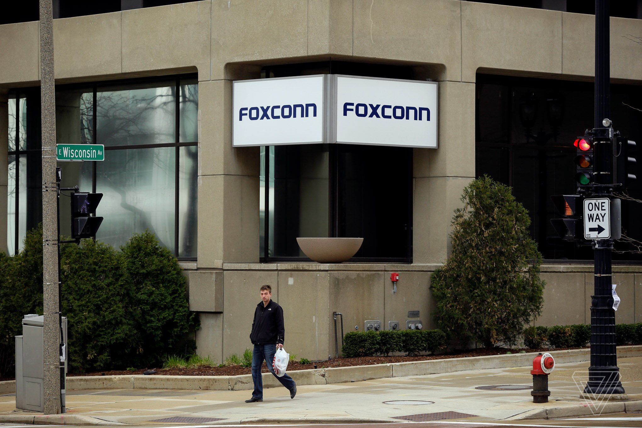 A man walks past an office building with the Foxconn name displayed outside on Wednesday, May 8 2019 in Milwaukee, Wisconsin. Foxconn is a electronics contract manufacturing company, which is constructing a plant in south eastern Wisconsin creating thousands of jobs. 