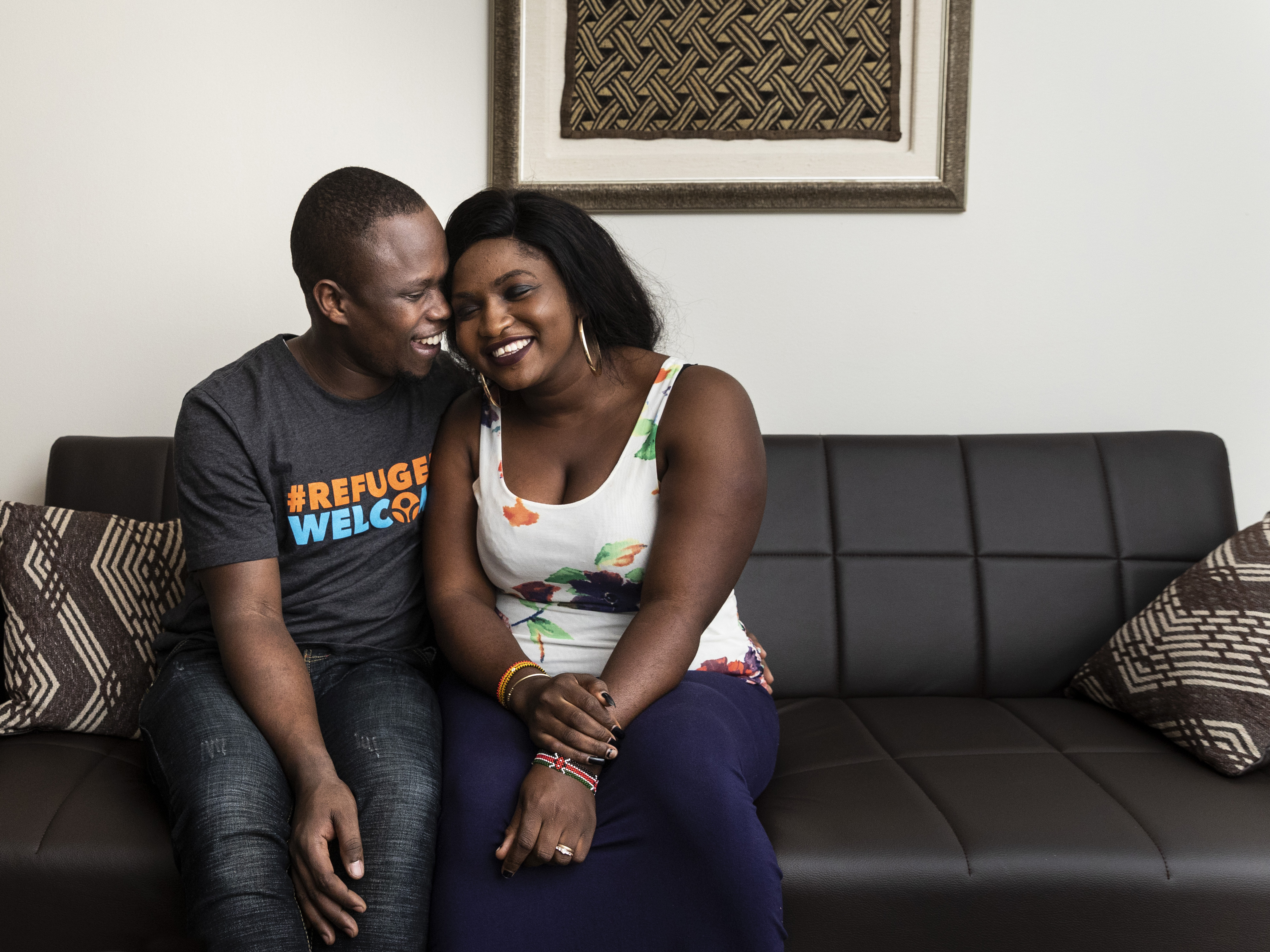 Celestine Mugisha and his wife, Winniefred Akello, embrace on the couch in their apartment in Rogers Park on the North Side, Jan. 30, 2020. Mugisha and Akello were married in Uganda in September 2016 and, days later, Mugisha moved to Chicago as part of the United States’ refugee resettlement program. More than three years later, Akello was also resettled through the program and the couple was reunited at O’Hare International Airport on Jan. 22, 2020.