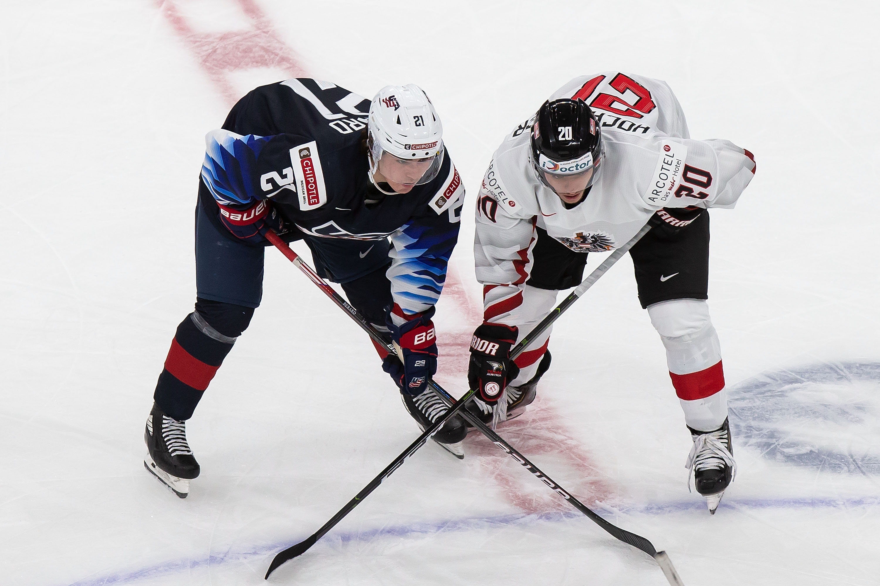 Brett Berard #21 of the United States lines up next to Fabian Hochegger #20 of Austria during the 2021 IIHF World Junior Championship at Rogers Place on December 26, 2020 in Edmonton, Canada.