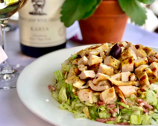 La Scala’s chopped salad served in front of a bottle of wine.