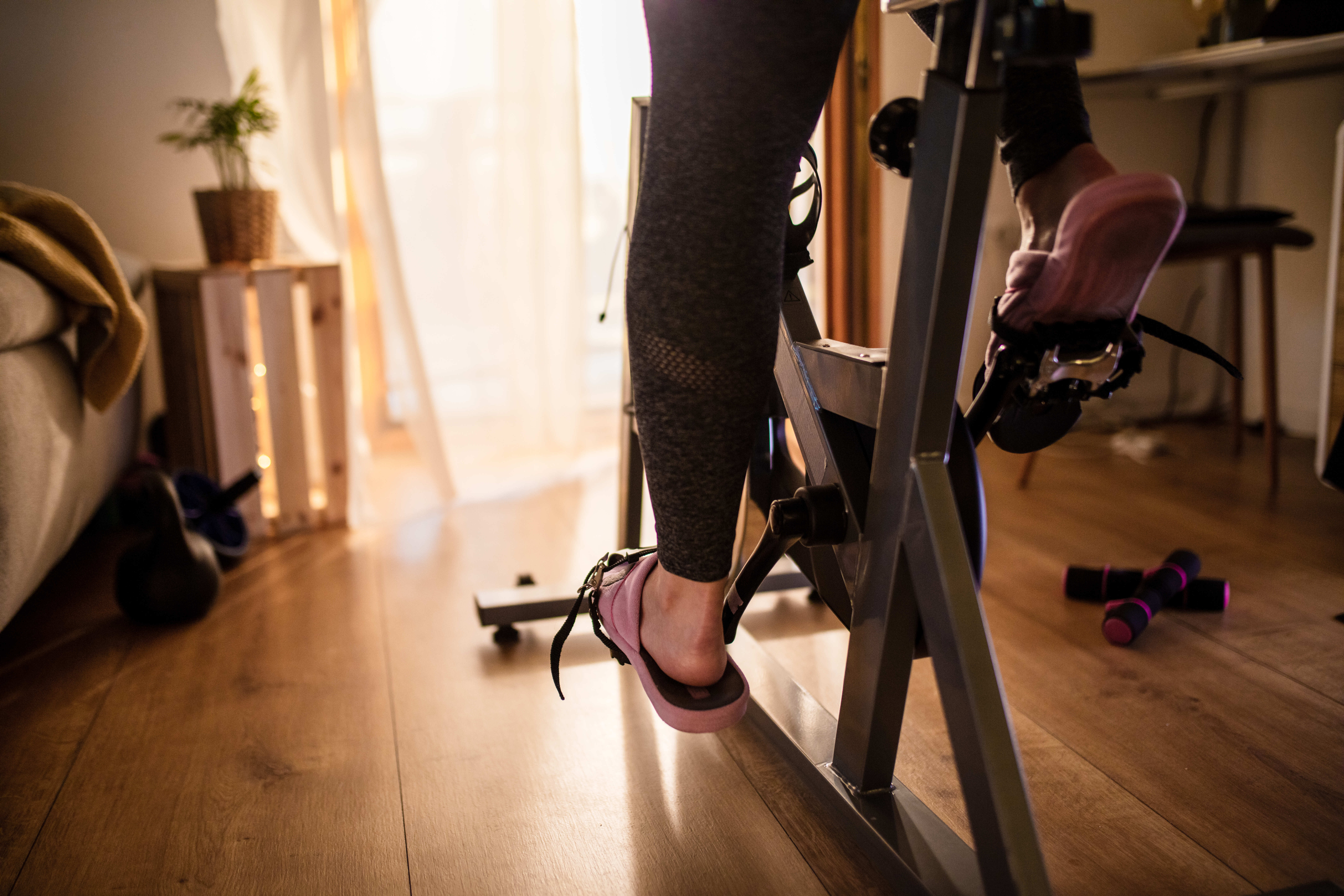 A woman’s feet on an at-home workout bike.