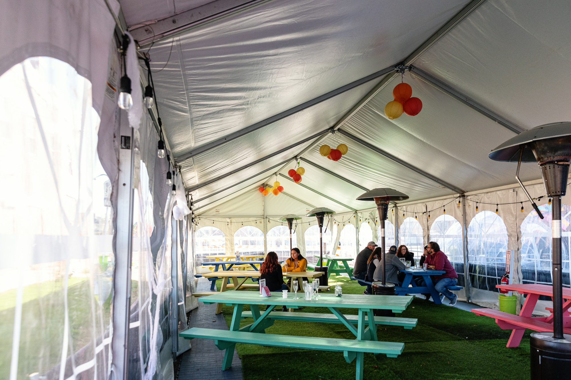 A heated indoor tent at Bobcat Bonnie’s is filled with colorful picnic tables.