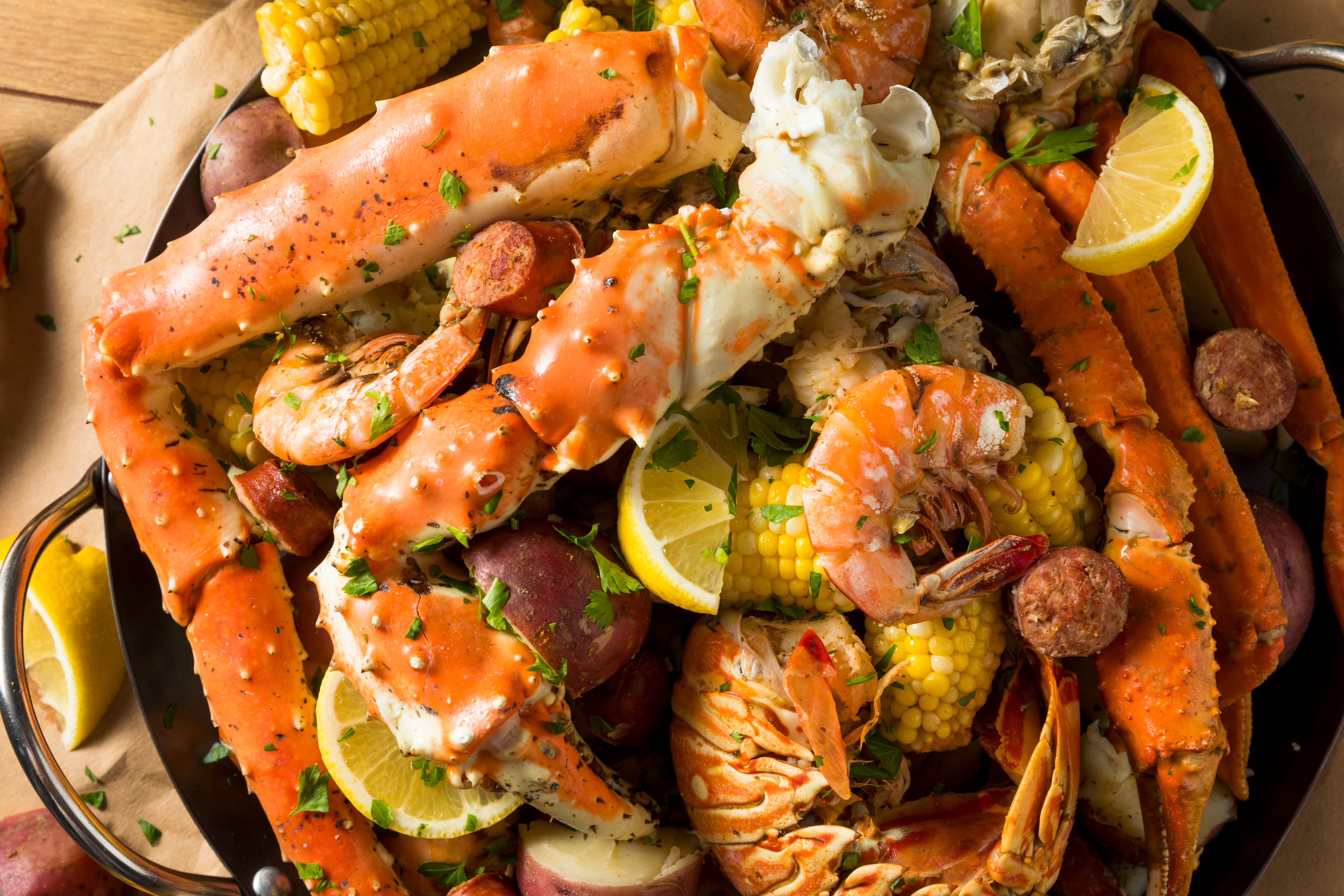 A homemade Cajun seafood boil with lobster, crab, and shrimp and slices of lemon.