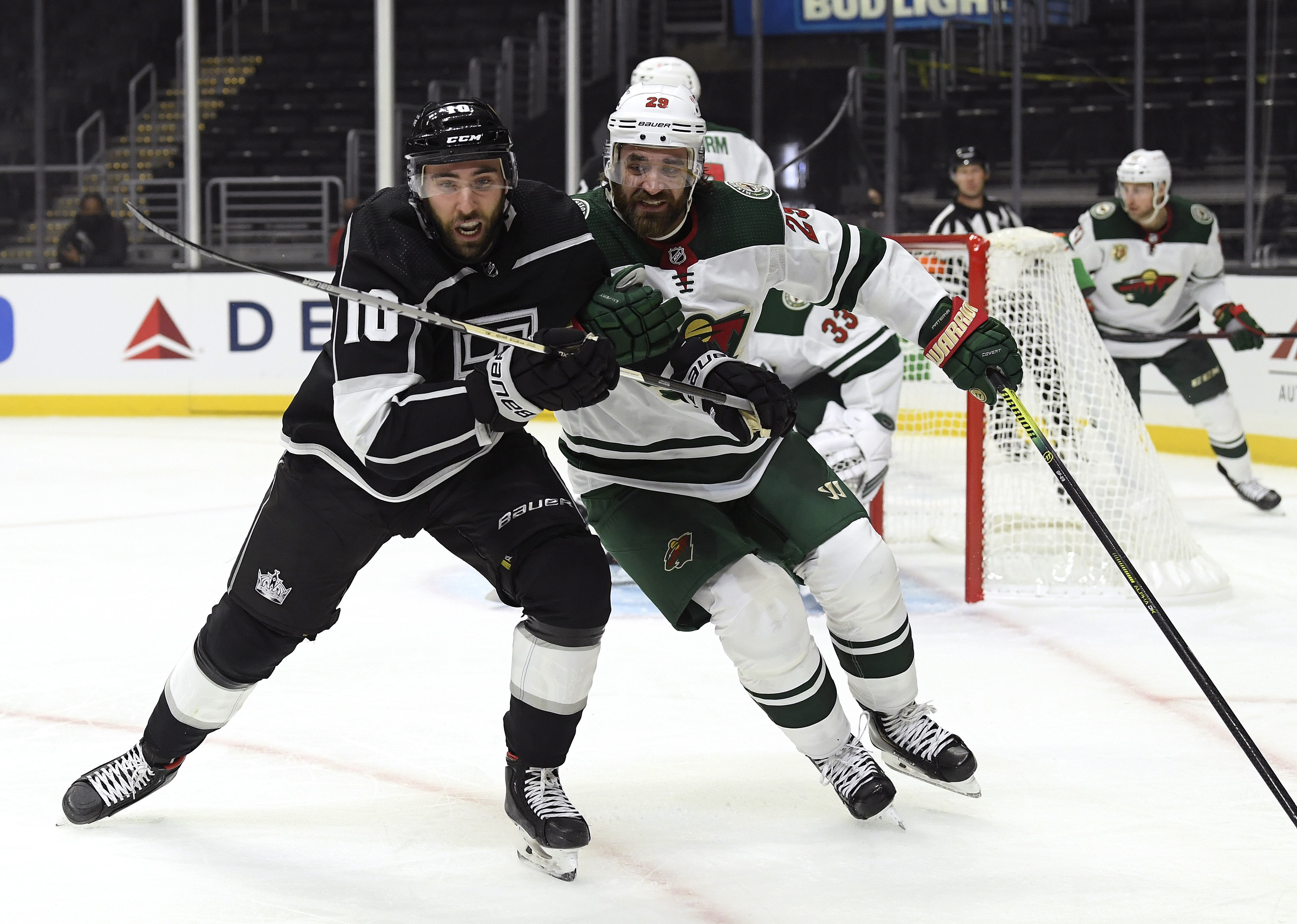 Michael Amadio #10 of the Los Angeles Kings and Greg Pateryn #29 of the Minnesota Wild skate after the puck during a 4-3 Wild overtime win in the season opening game at Staples Center on January 14, 2021 in Los Angeles, California.