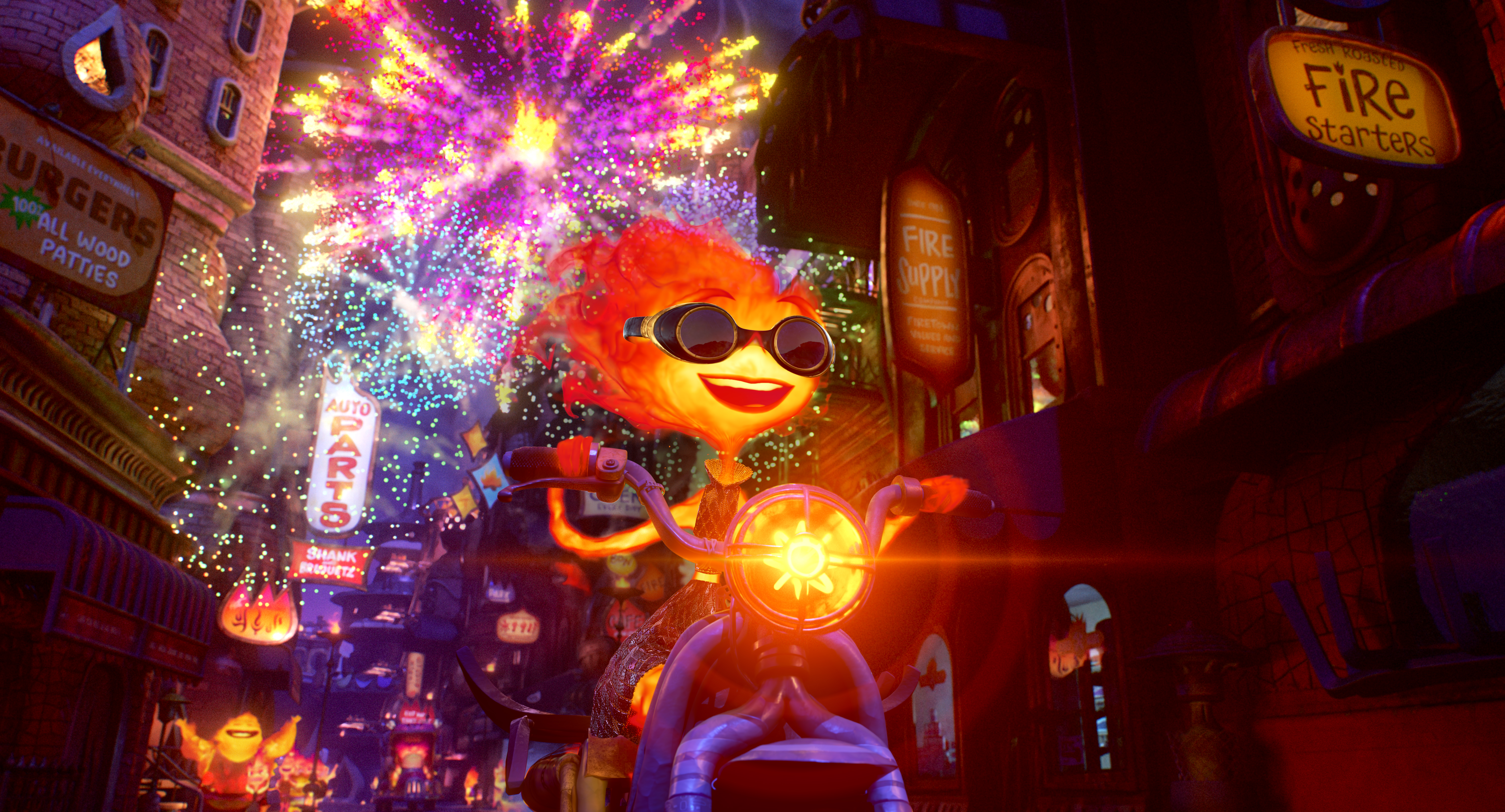 Ember, a woman made out of fire, drives through the streets of her hometown of Element City, grinning and wearing sunglasses as colorful fireworks go off in the sky behind her in Elemental