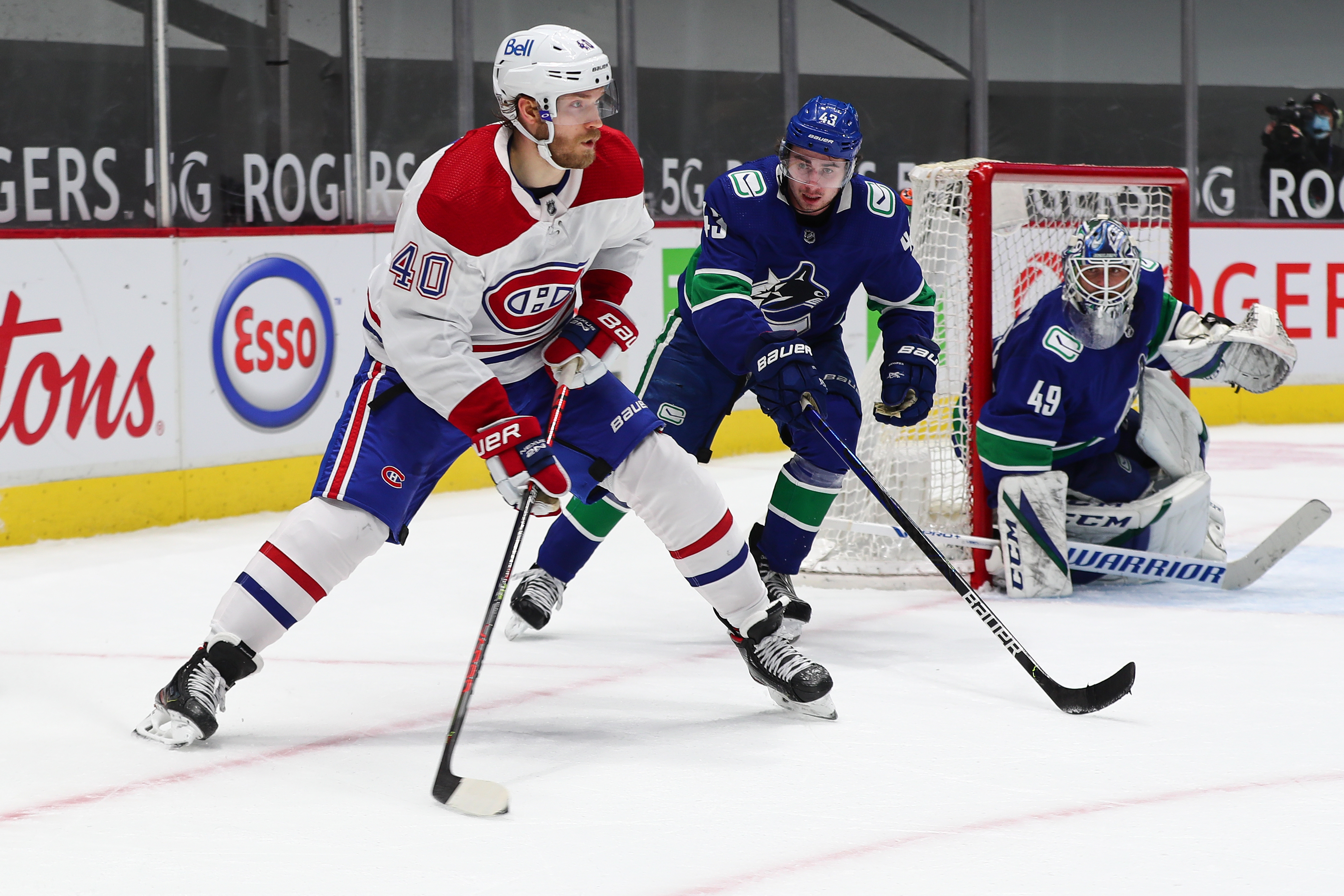 Montreal Canadiens Right Wing Joel Armia (40) plays the puck while watched by Vancouver Canucks Defenceman Quinn Hughes (43) during their NHL game at Rogers Arena on January 20, 2021 in Vancouver, British Columbia, Canada.