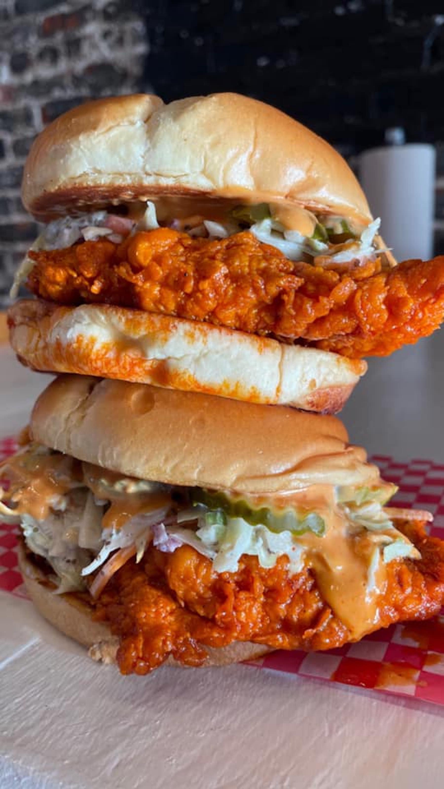 Two chicken sandwiches stacked on top of each other.