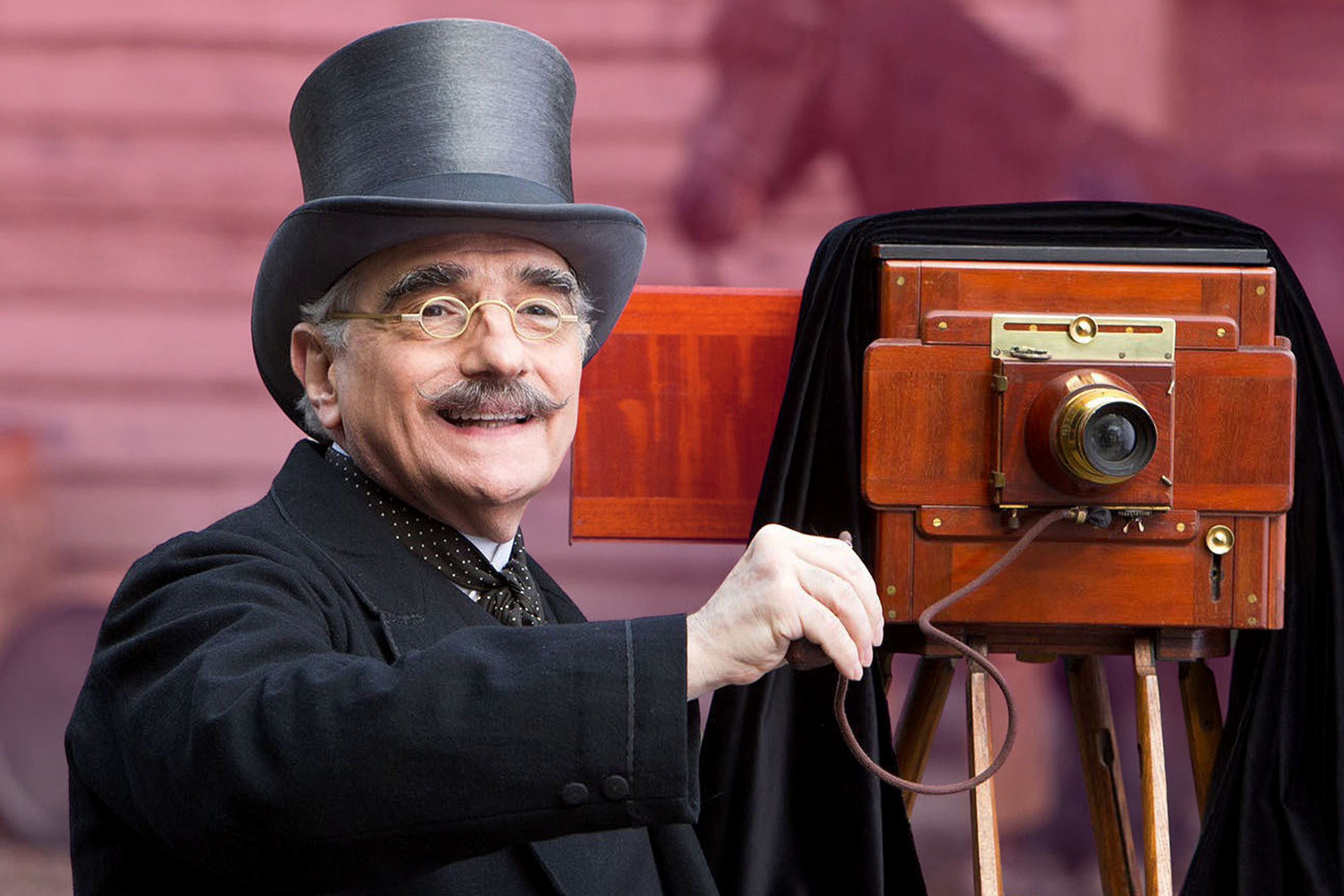 Martin Scorsese is top hat and coat with vintage camera
