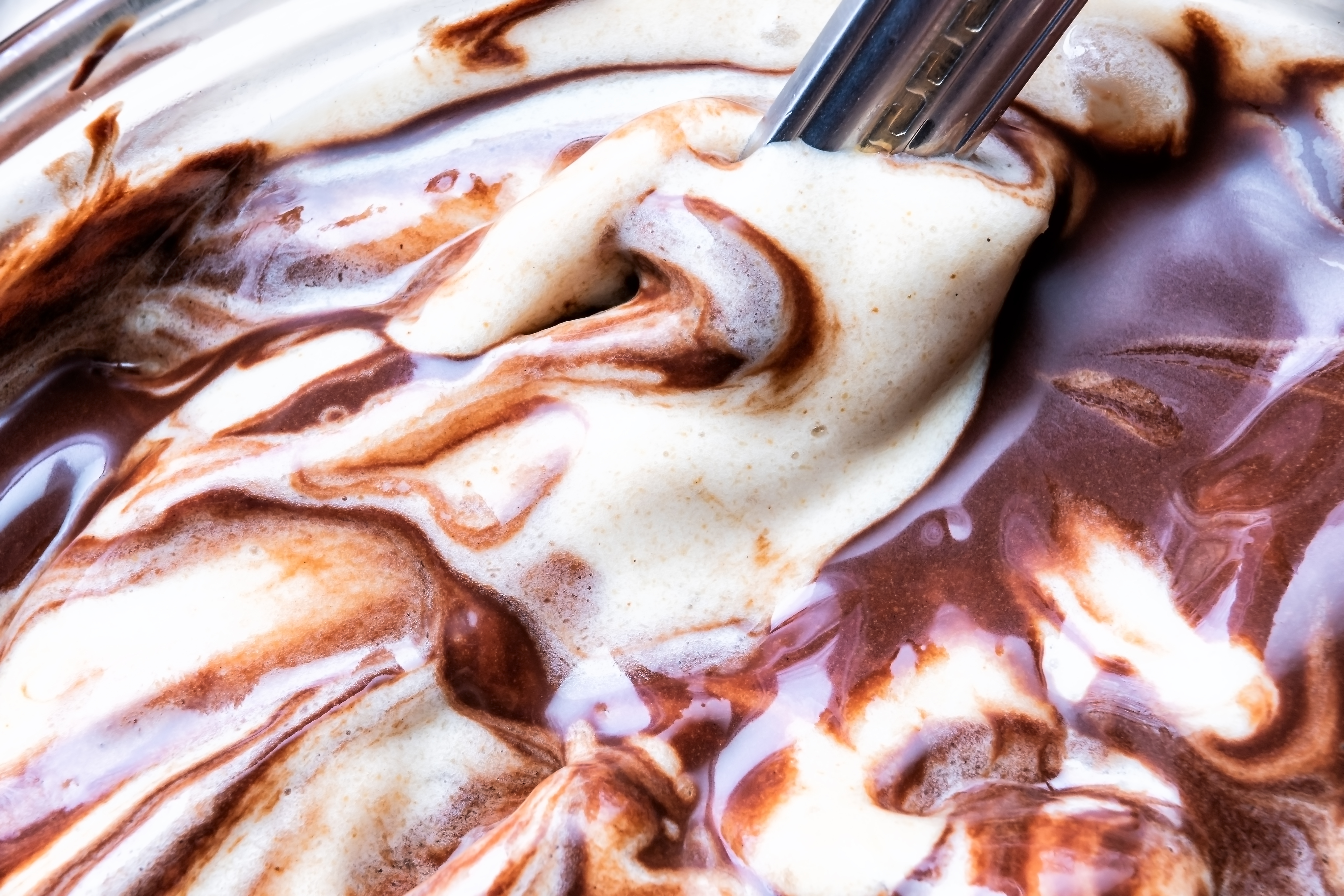 Close-up of melted chocolate and vanilla swirled ice cream.