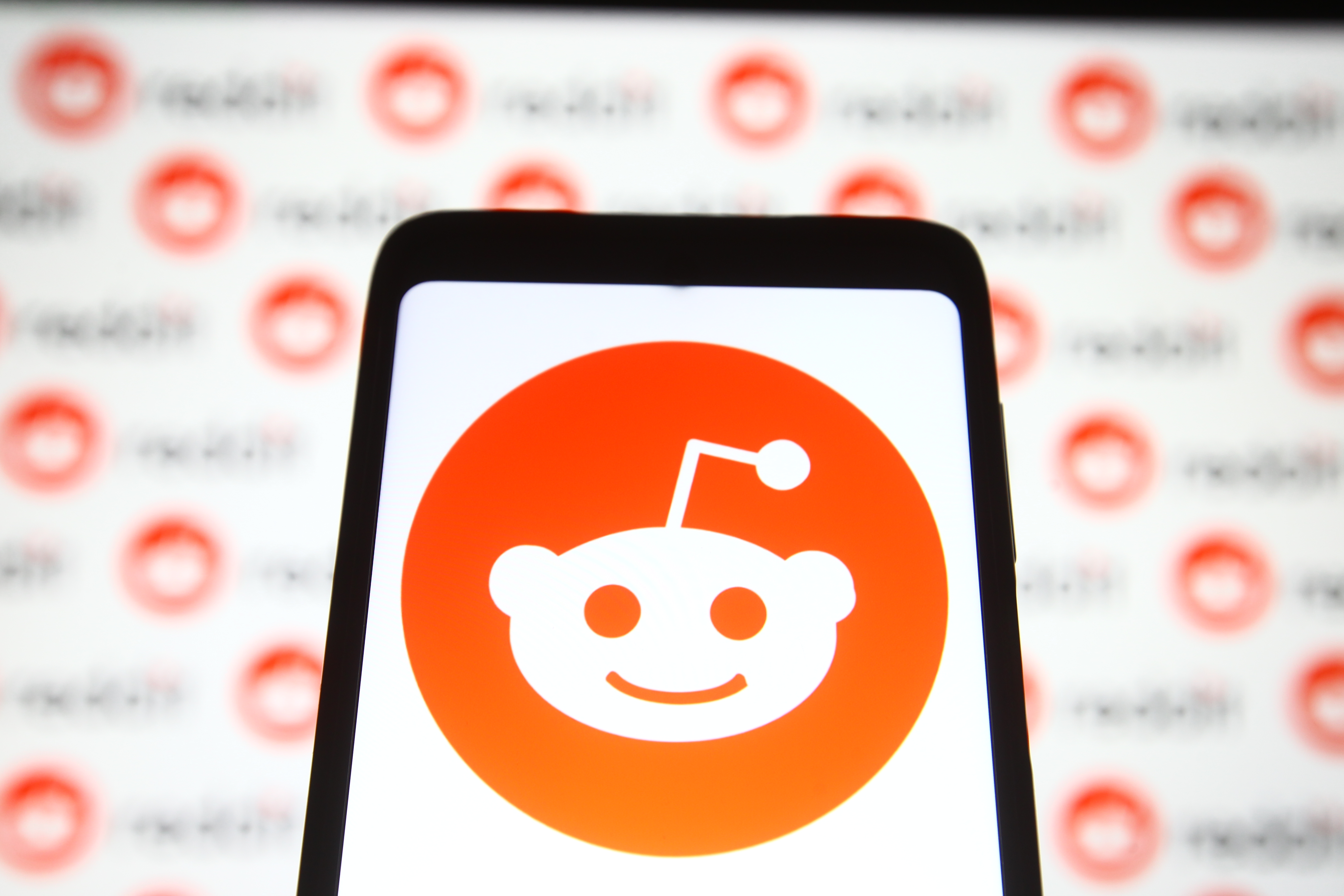 In this photo illustration a Reddit logo is seen on a mobile...