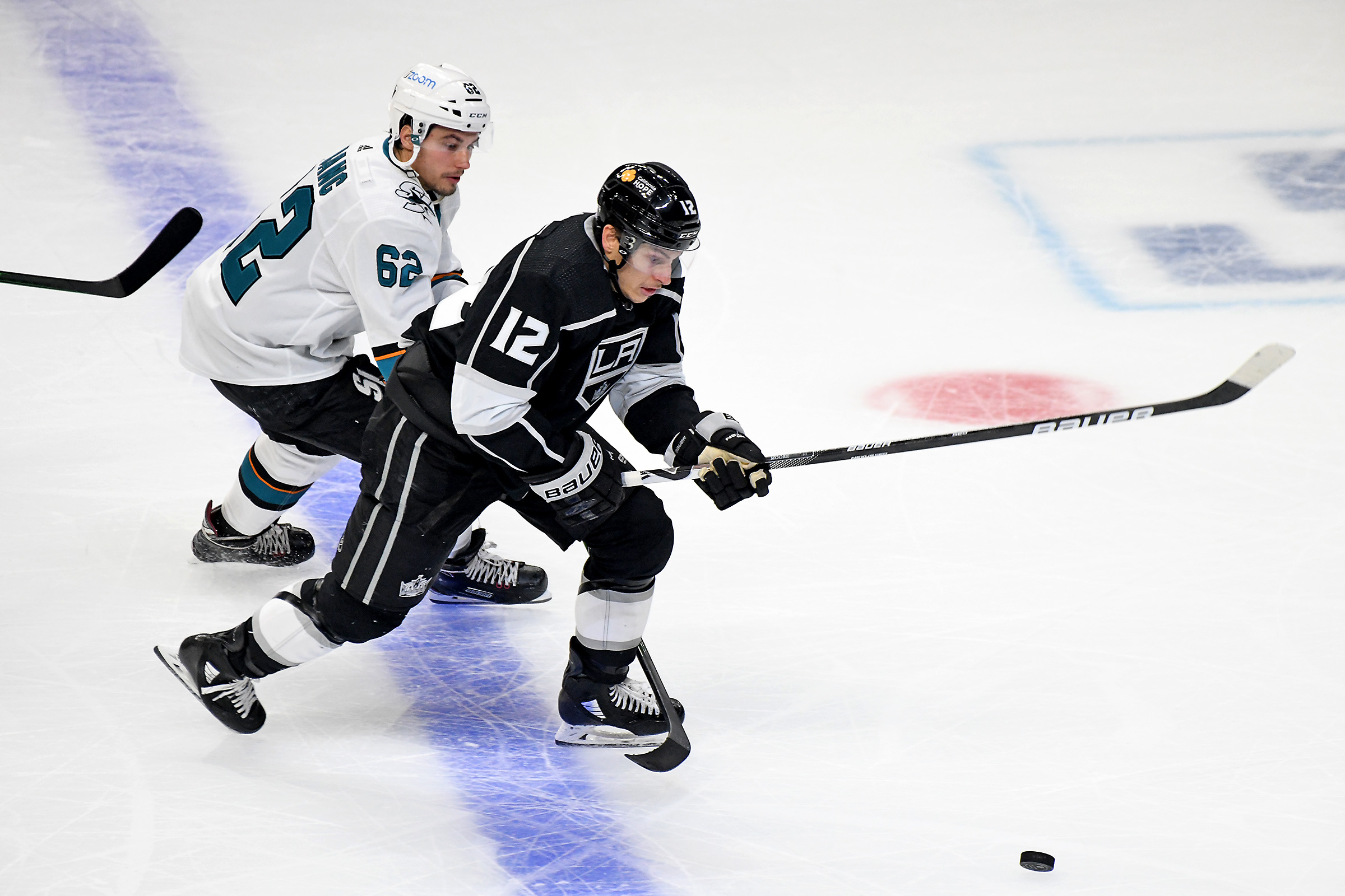 Los Angeles Kings Left Wing Trevor Moore (12) and San Jose Sharks Right Wing Kevin Labanc (62) battle for position during the second period on February 10, 2021 at the Staples Center in Los Angeles, CA.