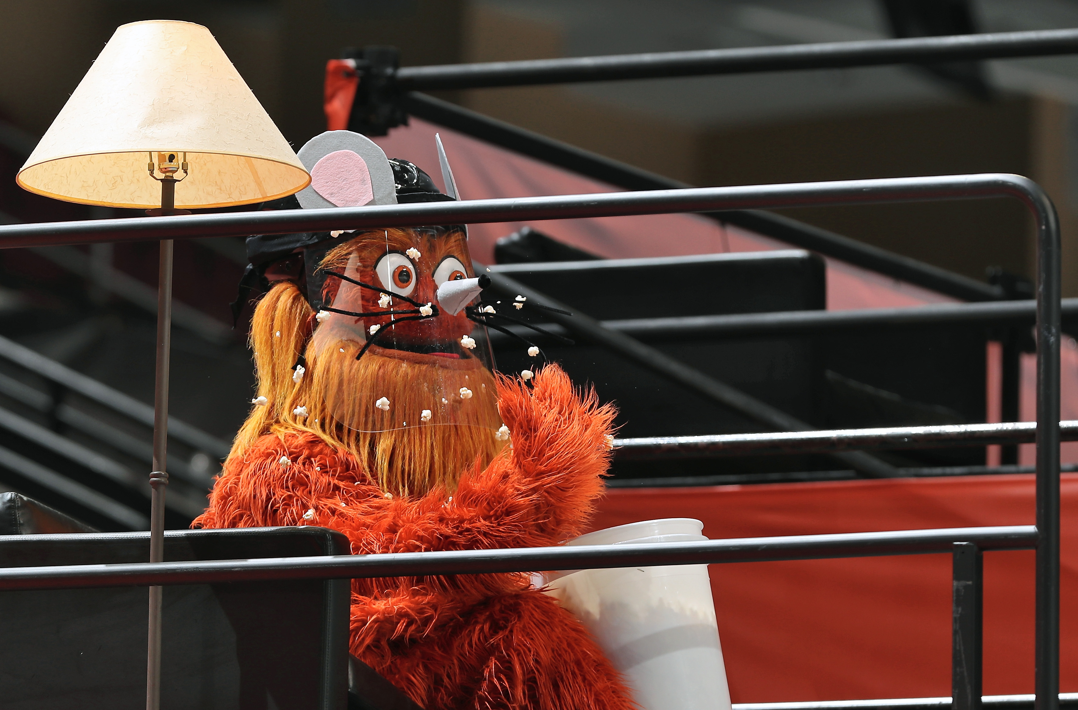 gritty the flyers mascot with a face shield and popcorn on his face