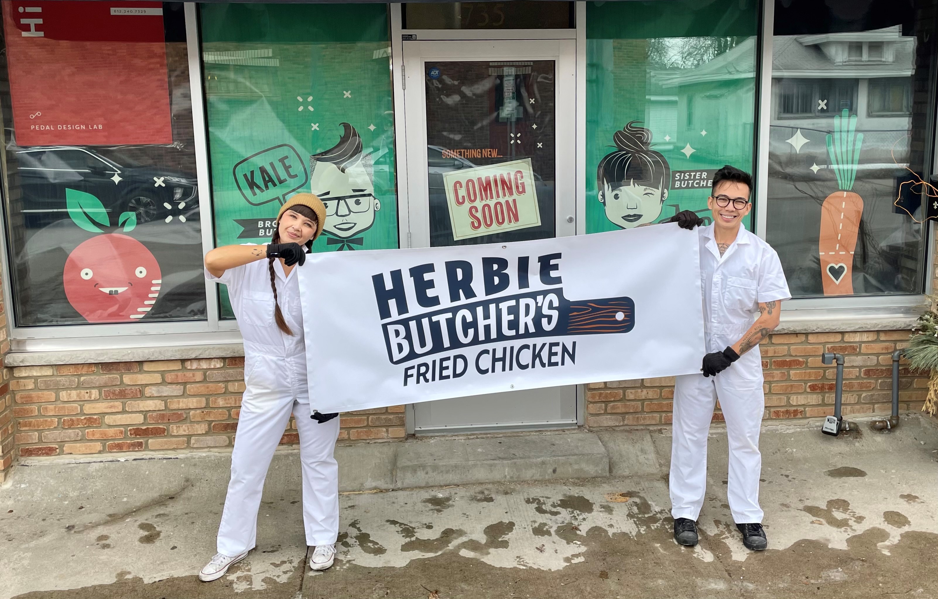 Aubry and Kale hold a white with black print banner, “Herbie’s Fried Chicken,” in front of the new storefront, decorated with aqua green paper sporting cartoon versions of the Walch siblings